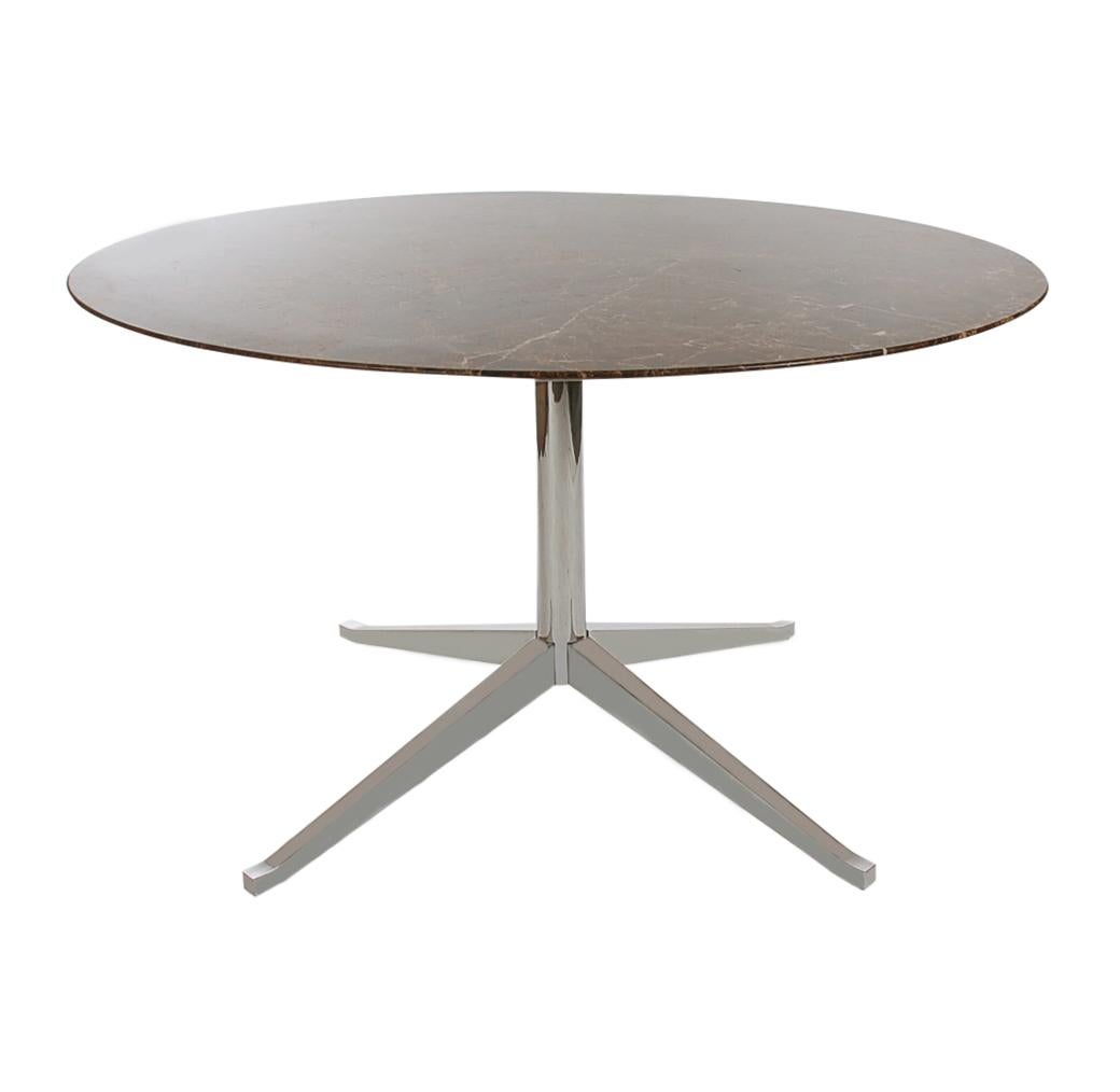 An elegant table designed by Florence Knoll and produced by Knoll Associates. It features a beautiful espresso marble top and a chrome-plated star base. Manufactures stamp present.