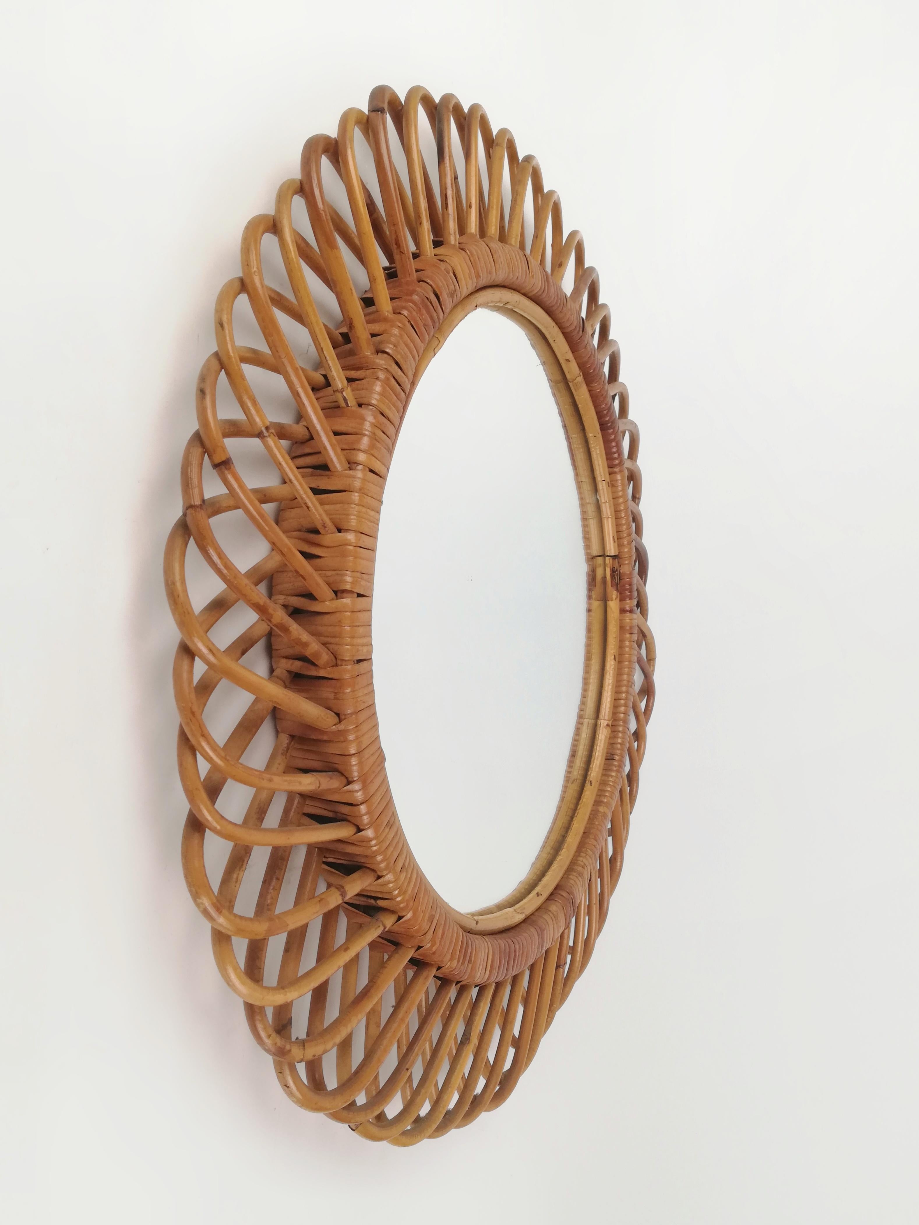 Circular mirror handcrafted in Italy during the 1960s
The craftsmen who made it flexed canes and fixed them with rattan for giving it this radial shape.
The style in which it is made makes it attributable to the Bonacina production, the most