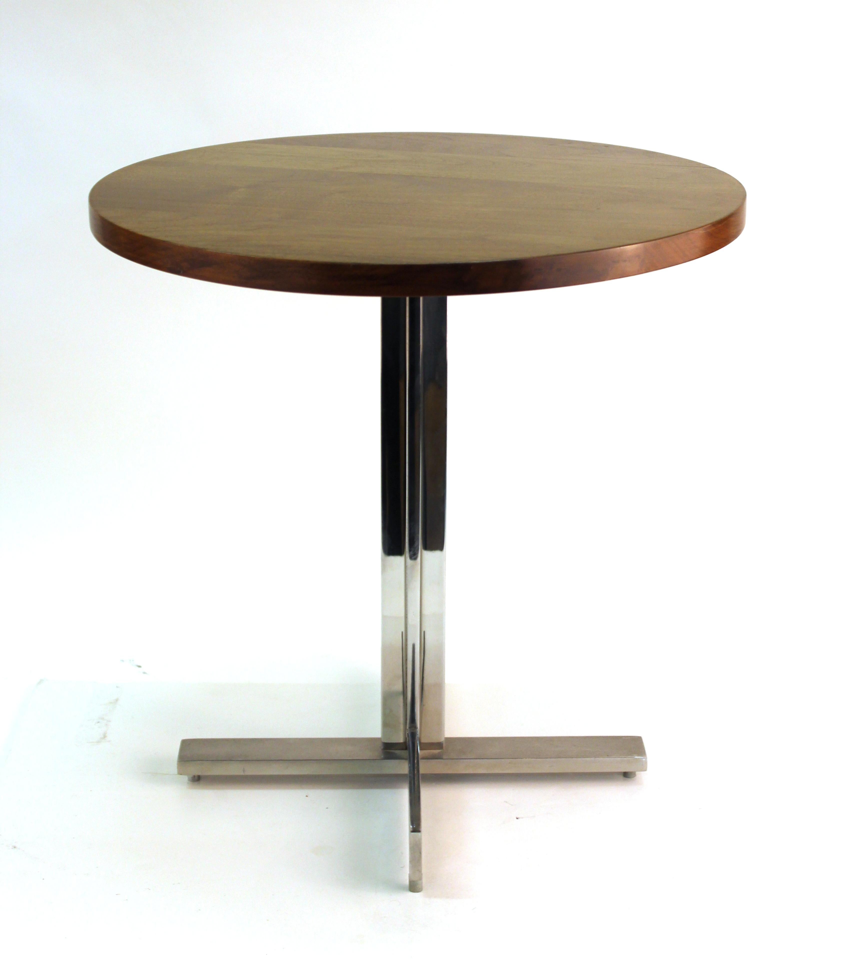 Mid-Century Modern round side table with walnut top and stainless steel base, designed in the style of Hans Eichenberger, designed in the 1960s. In great vintage condition with age-appropriate wear to the metal surfaces.