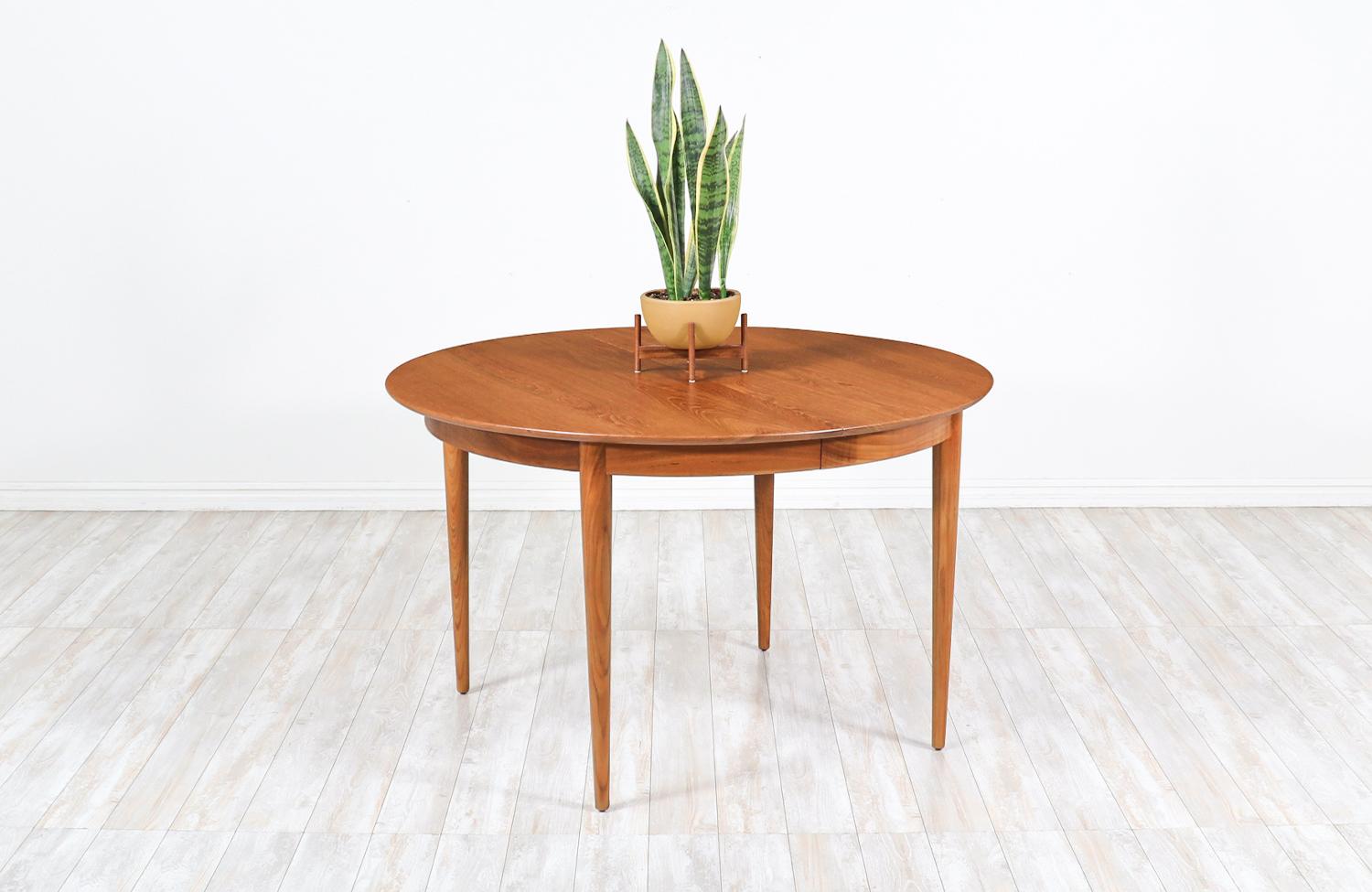 Mid-Century Modern round teak expanding dining table

Dimensions
29in H x 47in - 87 W x 47in D 
2x Extension Leaf 20in.