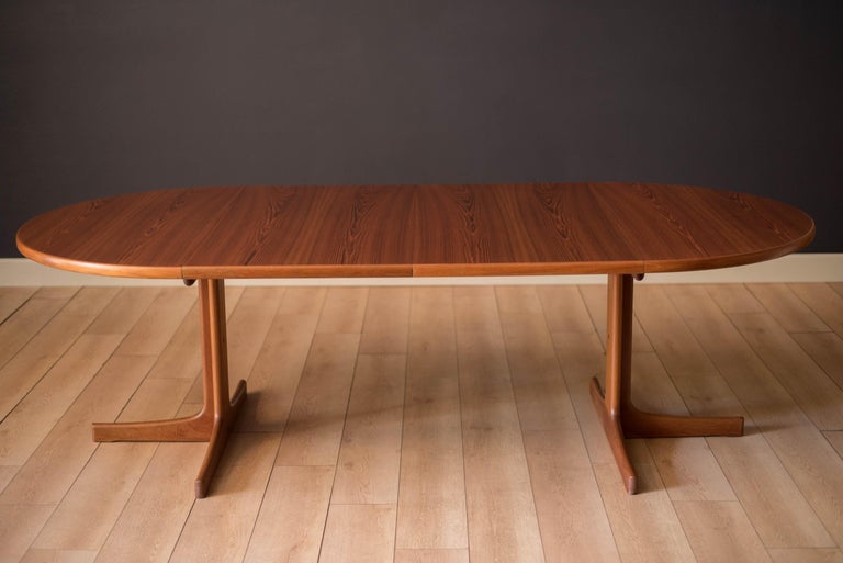 Vintage  round extension dining table designed by Karl-Erik Ekselius for J.O. Carlsson, Vetlanda, Sweden circa 1960s. This stunning piece features natural teak wood grains and a supporting pedestal base. Expands with two additional leaves to create