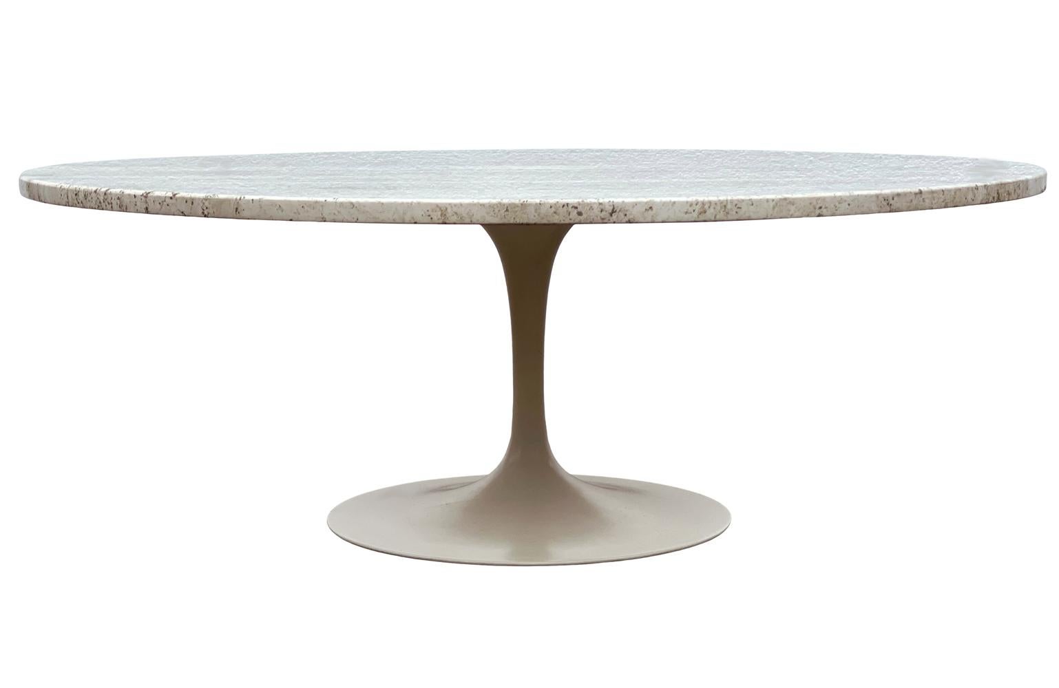 A custom circular coffee table designed by Eero Saarinen and produced by Knoll circa 1960's. The table features an off white powder coated pedestal base with a custom Italian travertine base. Manufacture label.