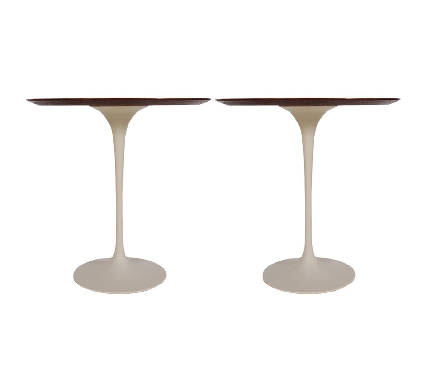 A matching pair of tulip tables designed by Eero Saarinen and produced by Knoll in 1971. These feature gorgeous walnut tops and white tulip bases. Manufacture labels.