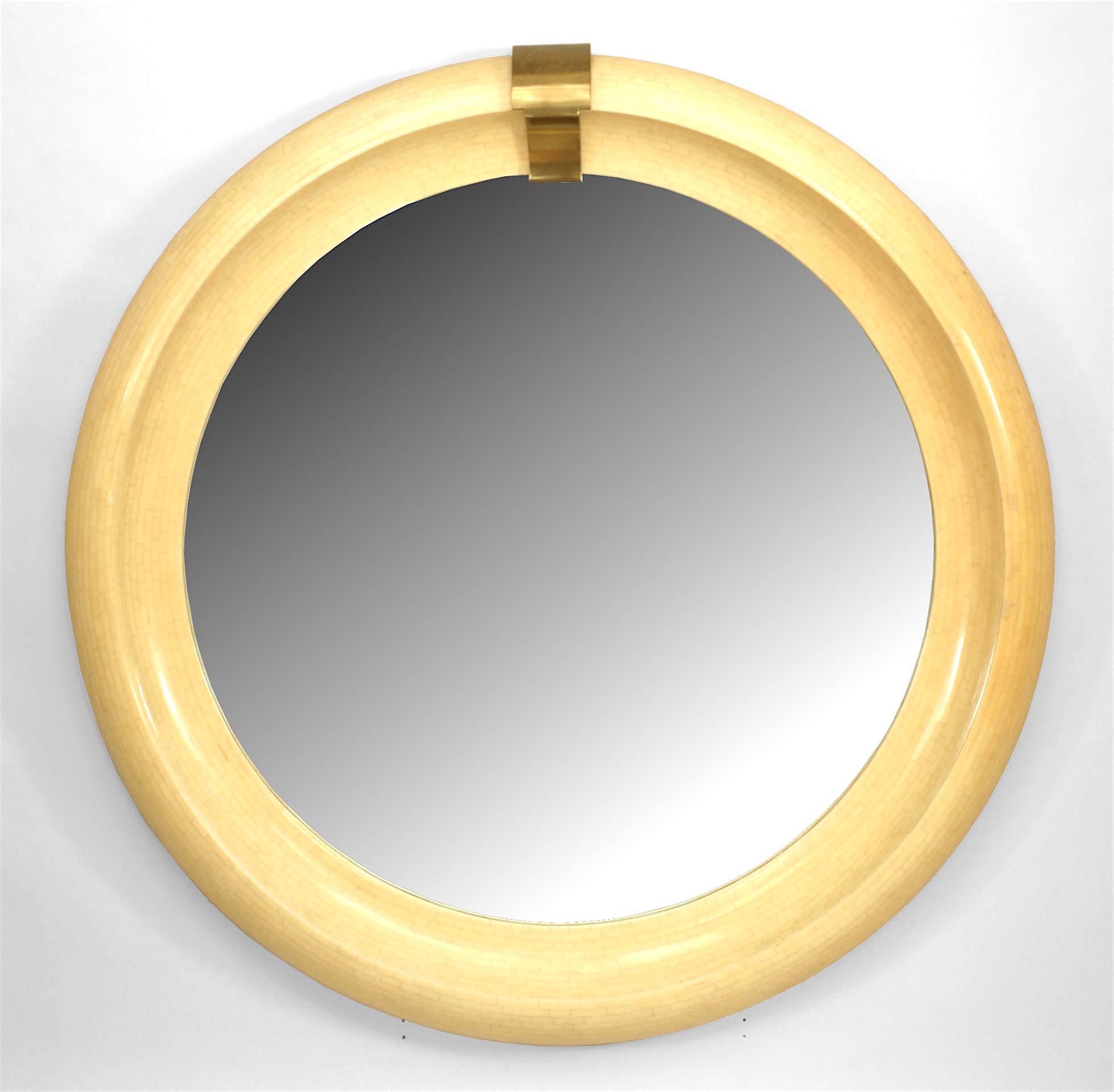 American Mid-Century Modern round mirror wall mirror with small brick design veneer and large bevelled form frame with a brass keystone top. (attributed to KARL SPRINGER)
