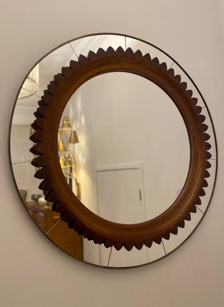 Mid-century modern round walnut and brass mirror by Fratelli Marelli,
 Italy circa 1950. Rare circular mirror with carved scalloped inner accent and brass gallery. Pair available, priced individually
Excellent condition wear consistent with age and