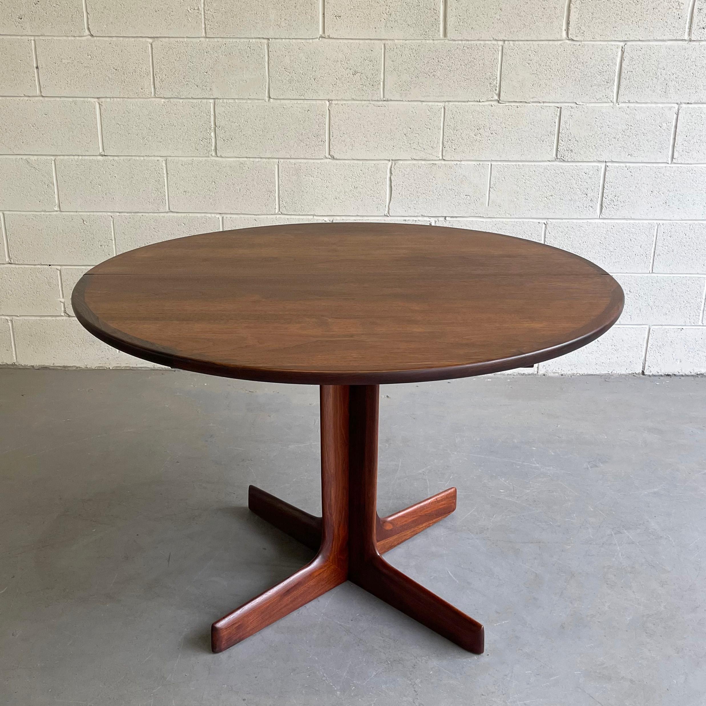 Mid-Century Modern, round, walnut dining table with pedestal base extends to 81 inches with two separate 18 inch leaves.