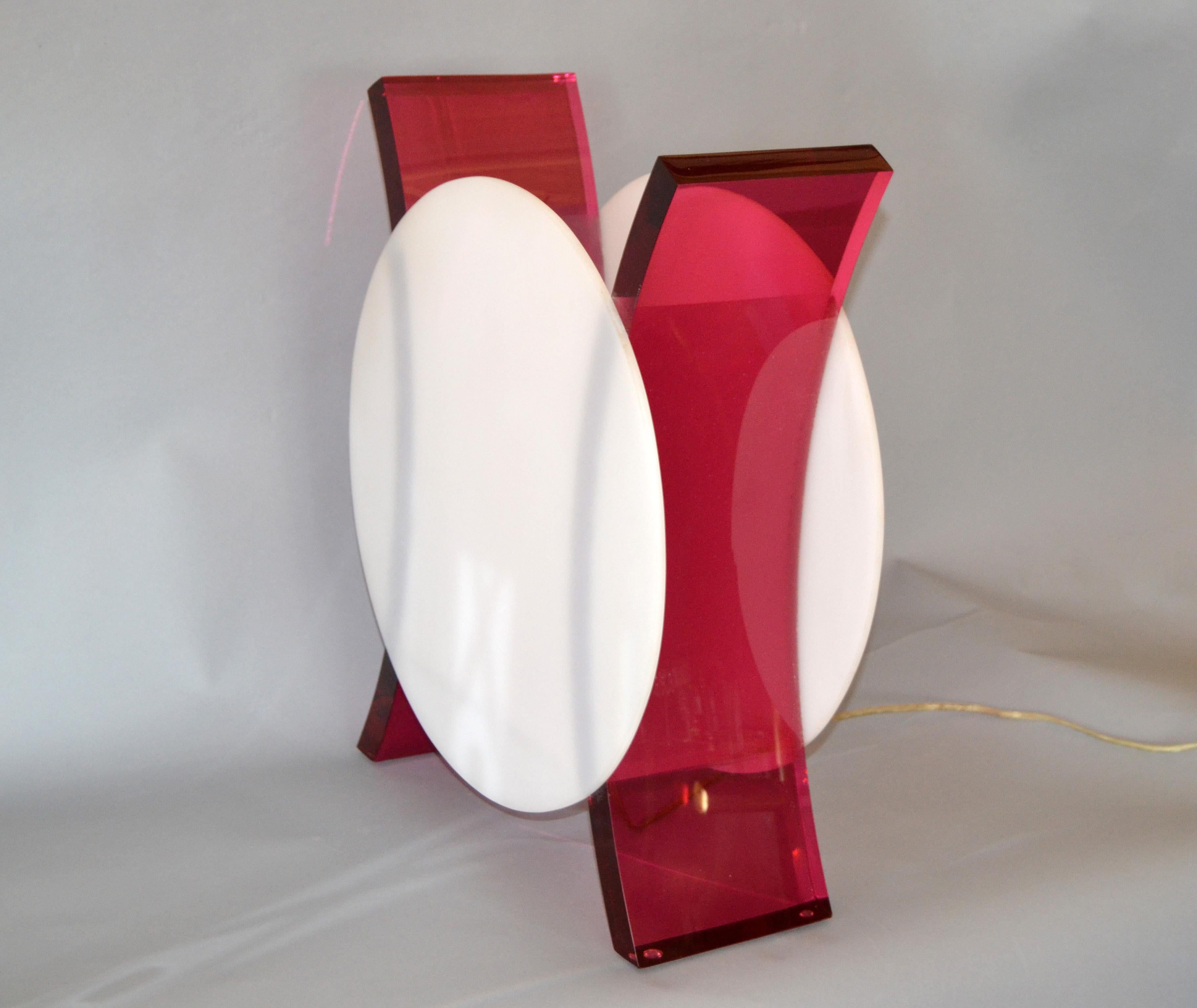 Mid-Century Modern white and pink acrylic sculptural table lamp.
The lamp has two round white discs and is sculptural framed on a pink base.
It takes one max. 75 watts light bulb.
In perfect working condition and wired for the U.S.
  