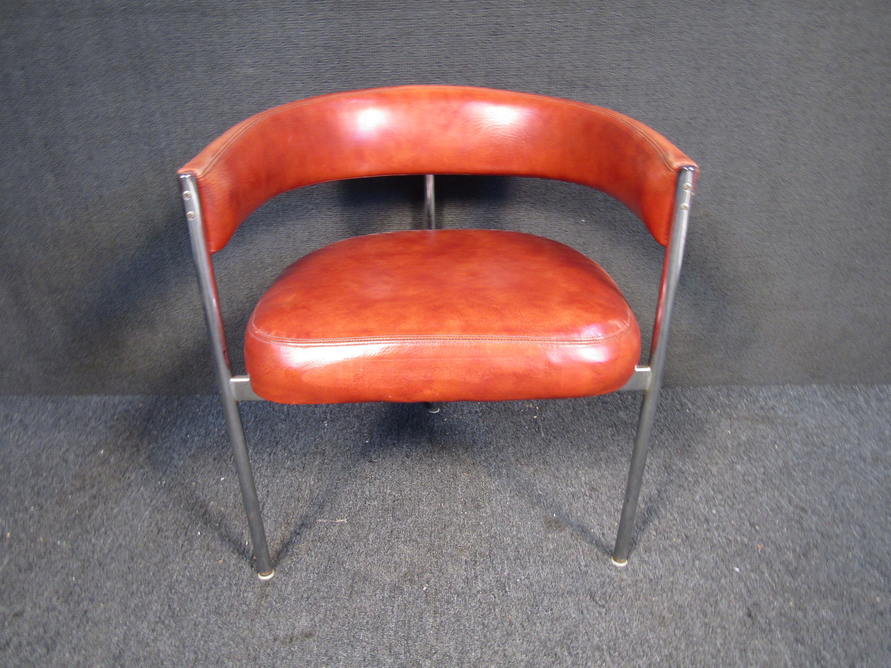 Avec un dossier arrondi, trois pieds et un revêtement en cuir riche, cette chaise vintage à dossier arrondi est parfaite pour ajouter un style du milieu du siècle à n'importe quel espace. Veuillez confirmer la localisation de l'objet auprès du