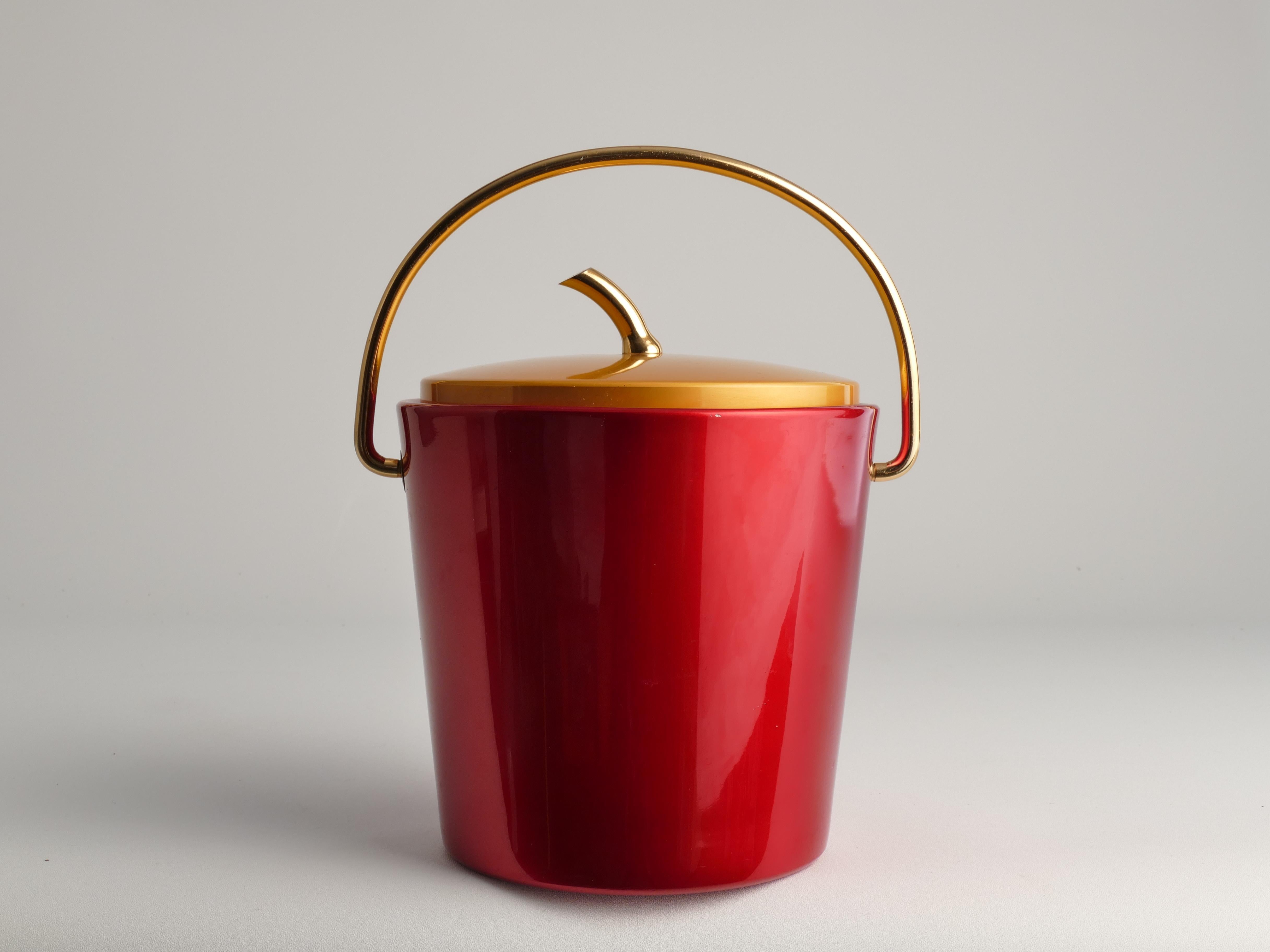 Rare and exquisite, this vintage ice bucket exudes retro charm with its shiny ruby red and gold aesthetics. The lid, adorned with an apple stalk handle, adds an elegant touch to its overall design, making it a captivating addition to any bar or