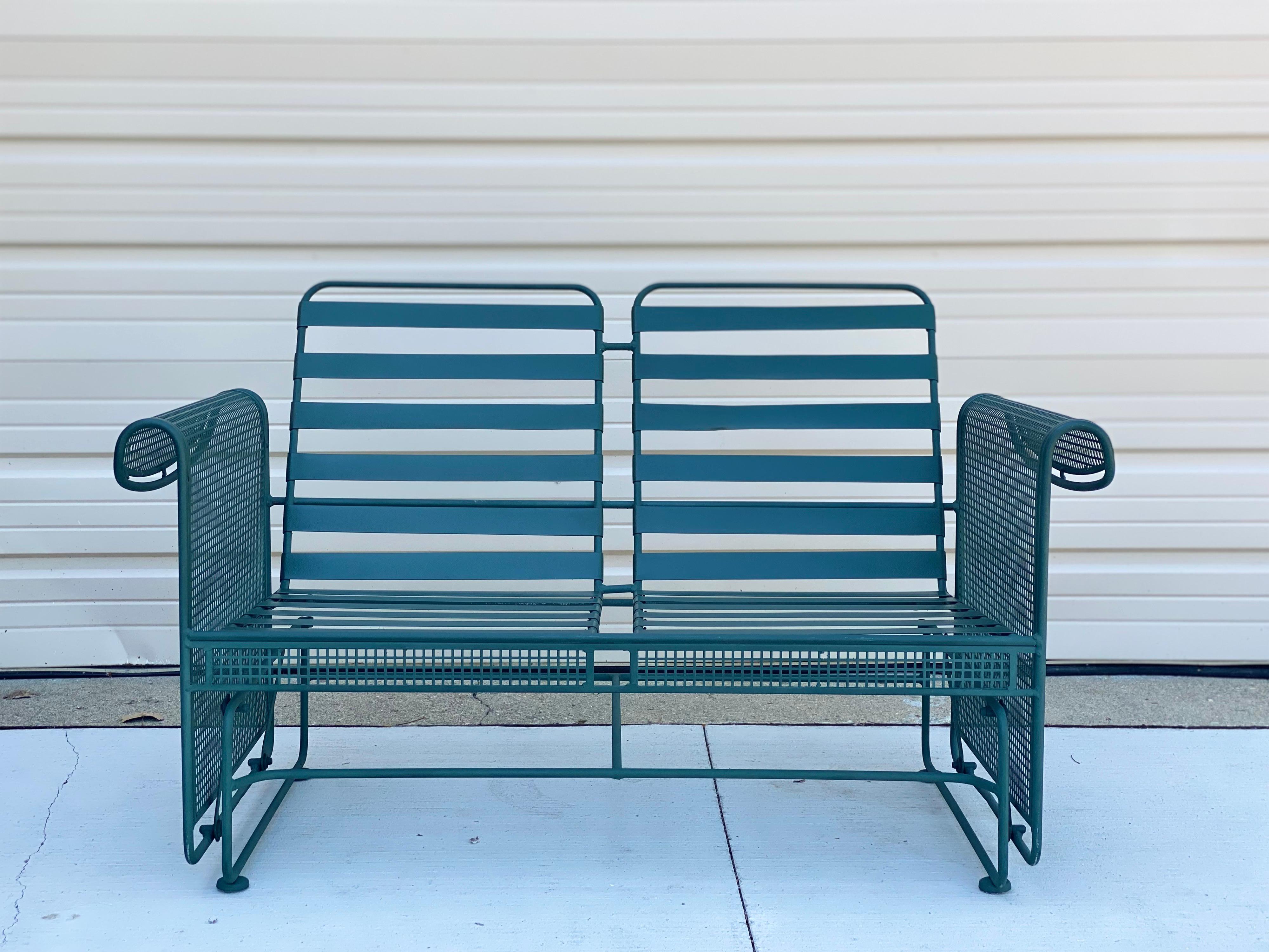 We are very pleased to offer a vintage, outdoor patio set by Woodard, circa the 1950s. With a one two-seat sofa, two chairs, one ottoman, and a coordinating coffee table and side table, this set is crafted in iron and showcases a solid green