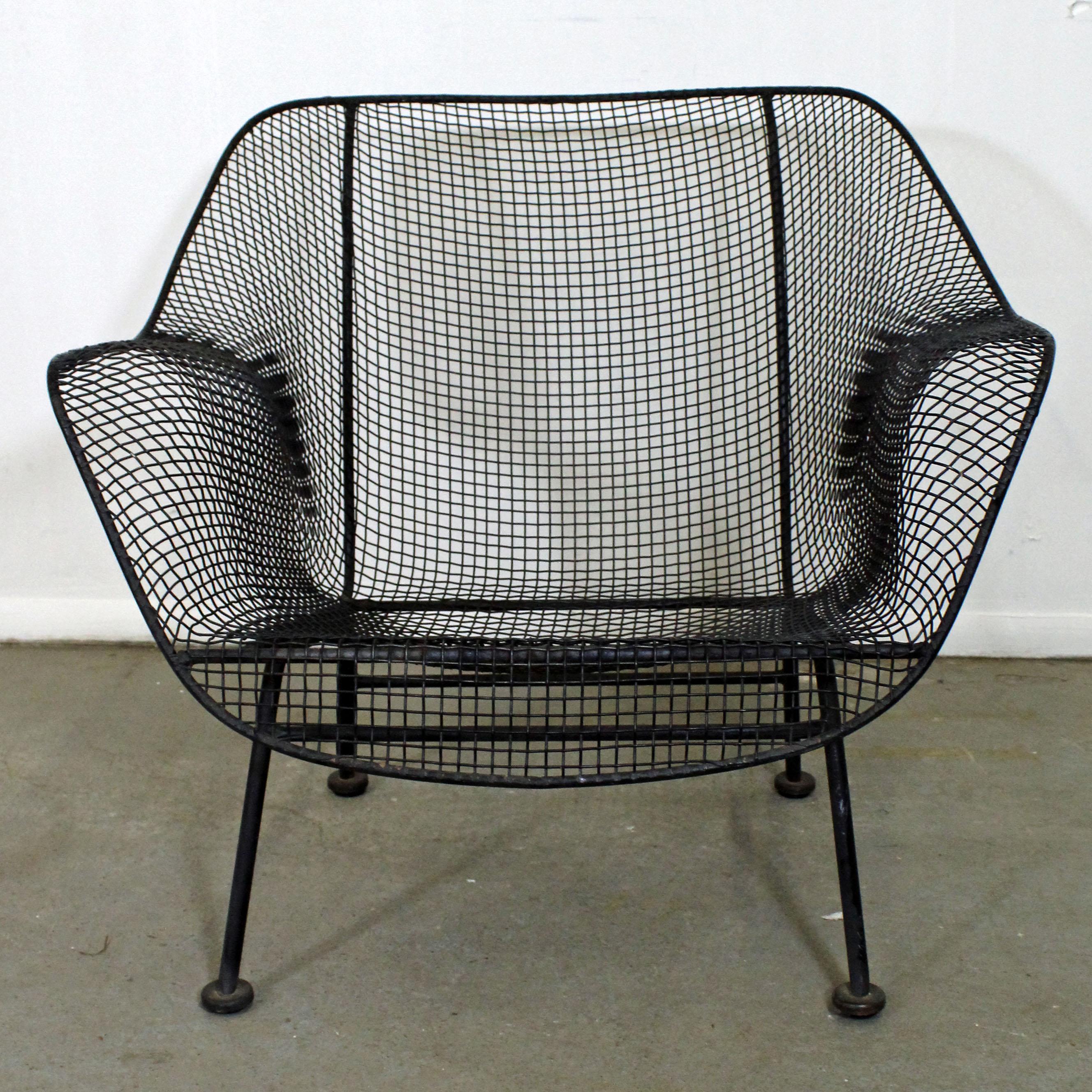 What a find. Offered is hard-to-find outdoor lounge chair made by Russell Woodard 'Sculptura'. It has a wrought iron frame with woven mesh steel seats to withstand all weather conditions. Also features a low-slung seat for outdoor lounging. It is in