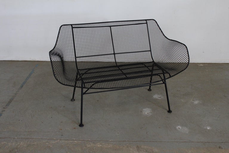 Mid-Century Modern Russell woodard sculptura outdoor wrought iron bench
Offered is a vintage outdoor bench by Russell Woodard 'Sculptura'. It has a wrought iron frame with a low-slung woven mesh steel seat made to withstand all weather conditions.