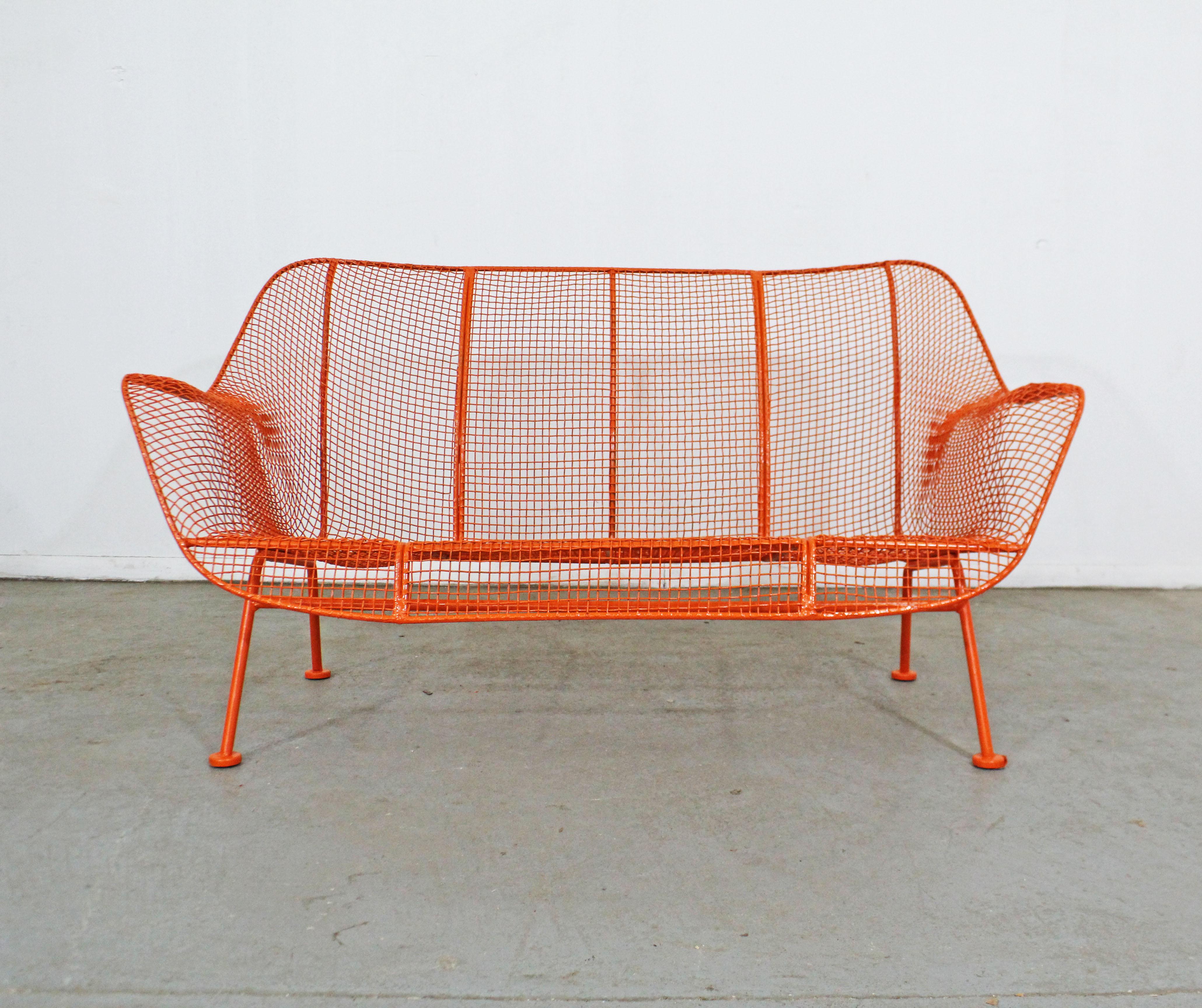 What a find. Offered is a vintage outdoor bench by Russell Woodard 'Sculptura'. It has a wrought iron frame with a low-slung woven mesh steel seat made to withstand all weather conditions. Perfect for outdoor lounging. It is in good condition,