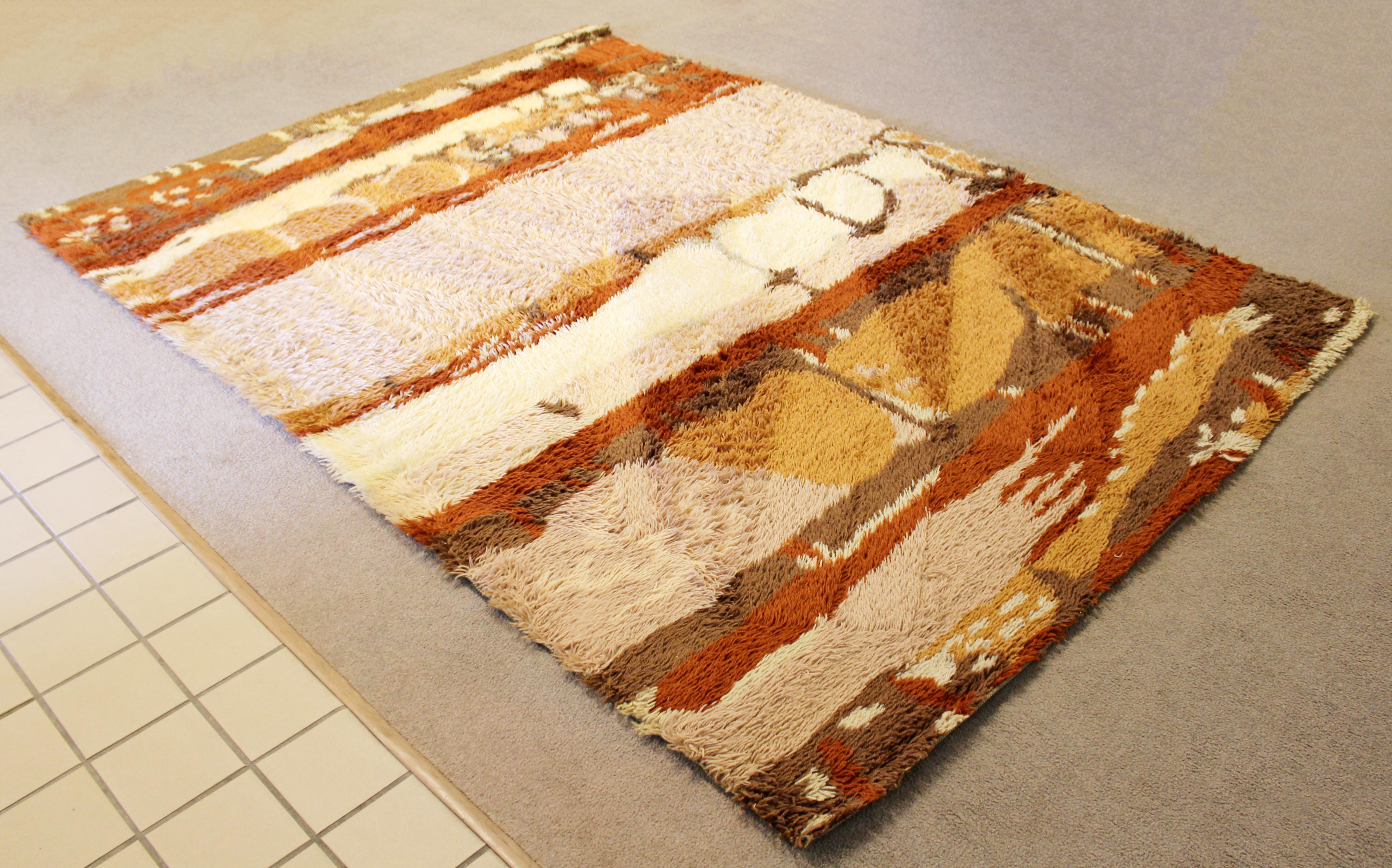 For your consideration is a vibrant, Danish, rectangular Rya area rug or carpet, with a rust, brown and cream pattern, circa 1960s. In very good condition. The dimensions are 72