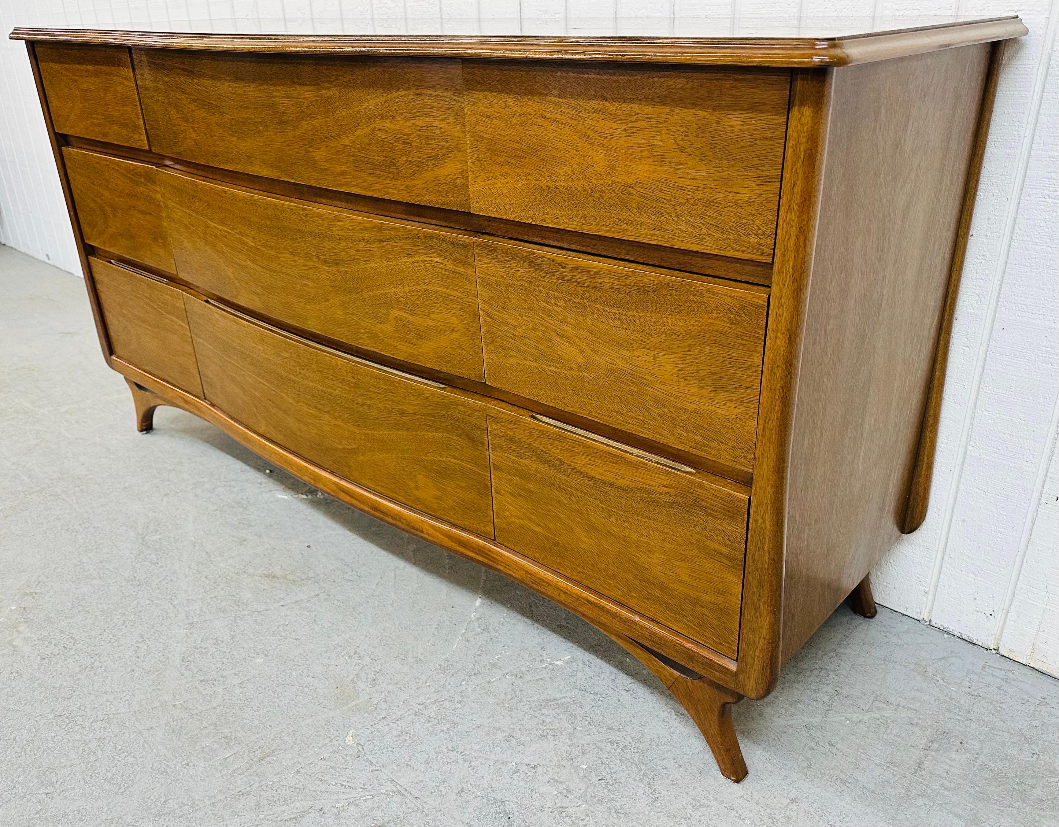 This listing is for a Mid-Century Modern RWAY Walnut Triple Dresser. Featuring a straight line design with nine drawers for storage, curved legs in the manner of designer Vladimir Kagan, and a beautiful walnut finish. This is an exceptional