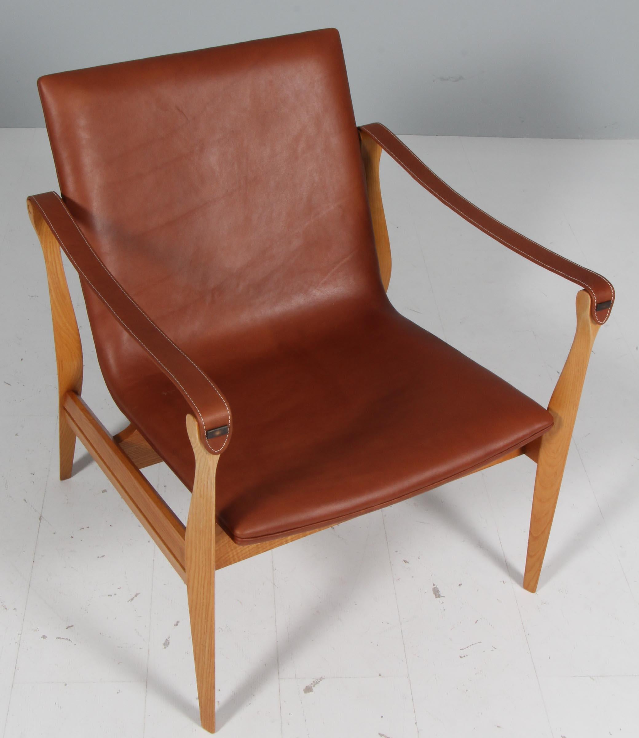 Very beautiful Safari Chair by Ebbe & Karen Clemmensen for Fritz Hansen designed in 1958 and produced in Denmark. The frame is made of ash and the seat is newly upholstered with a tan full grain aniline leather. Both chairs are in a very good