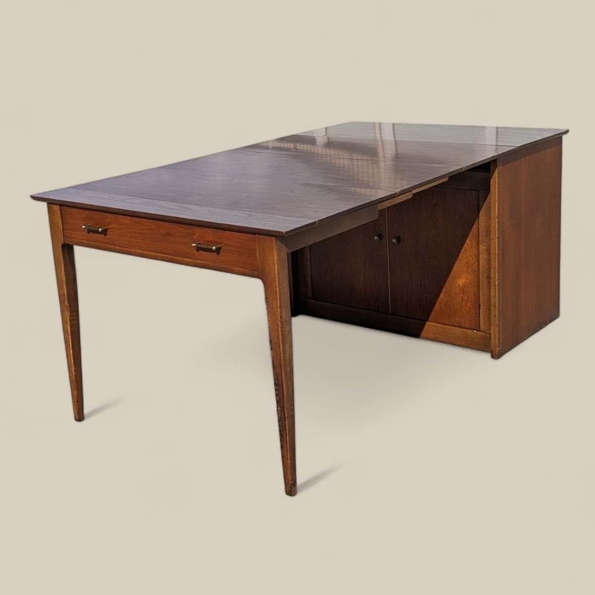 Te presentamos un raro e ingenioso hallazgo de la modernidad de mediados de siglo: el Armario Mesa de Comedor Convertible Extendomatic de Saginaw Furniture. Fabricada por Saginaw Furniture en los años 50 o 60, esta versátil pieza personifica el