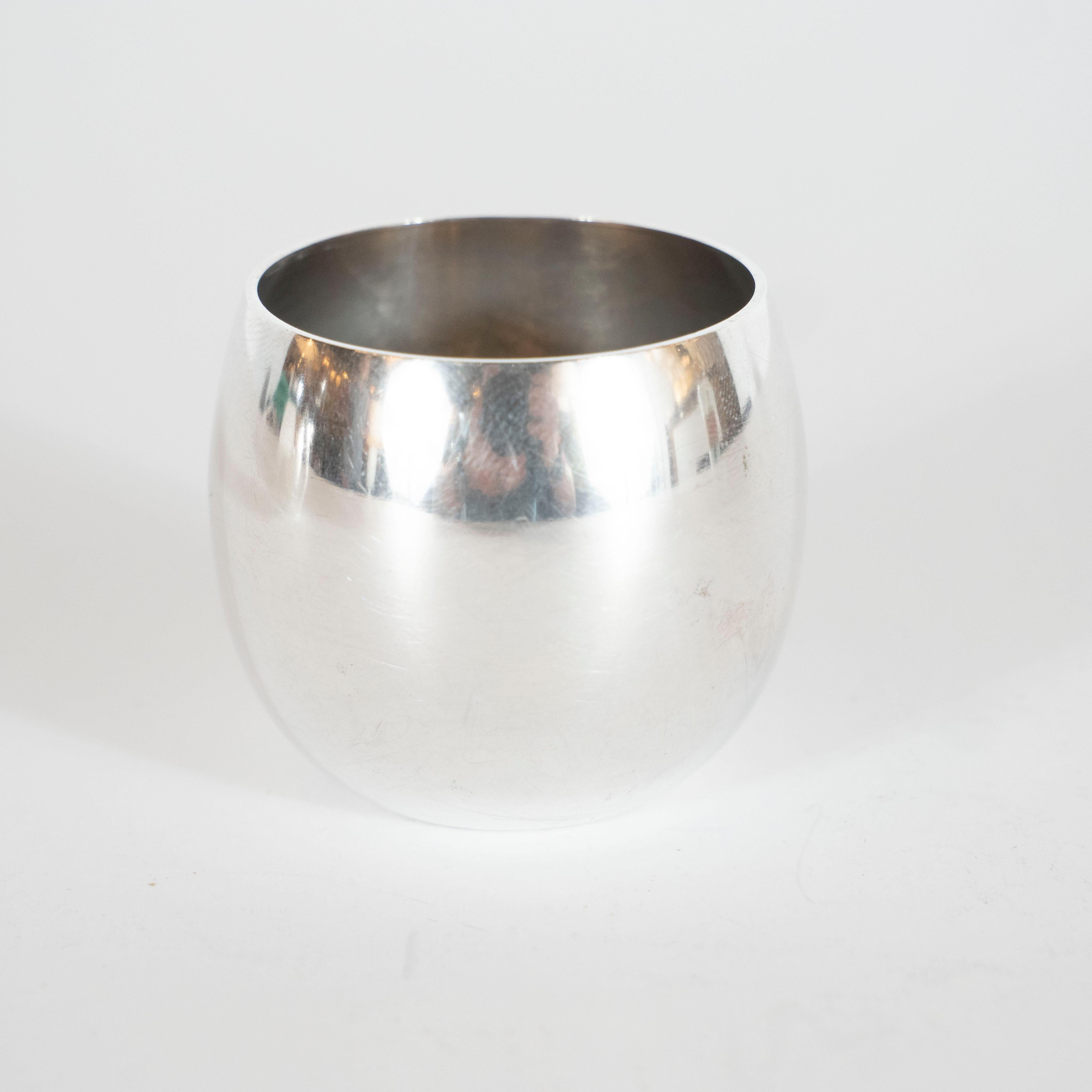 This elegant and understated set of salt and pepper cellars were realized by Tiffany & Co.- one of America's most esteemed producers of fine sterling silver objects and jewelry since 1837. Each offers a gently curved cylindrical body with an open