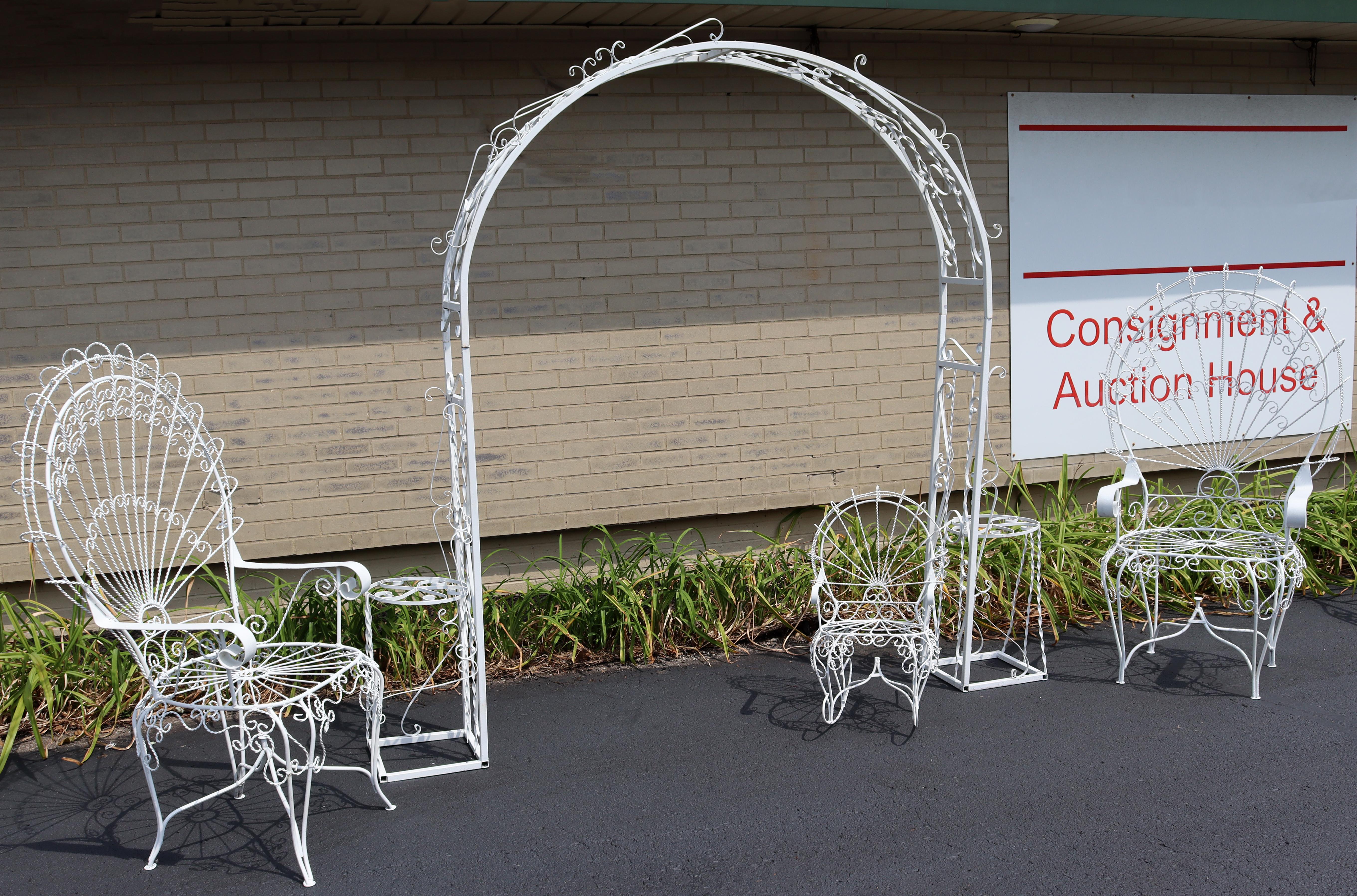 For your consideration is an elegant, outdoor, twisted wrought iron patio set; including a trellis, a child's rocker, and pair of peacock chairs, by Salterini, circa the 1950s. In very good vintage condition. The dimensions of the peacock chairs