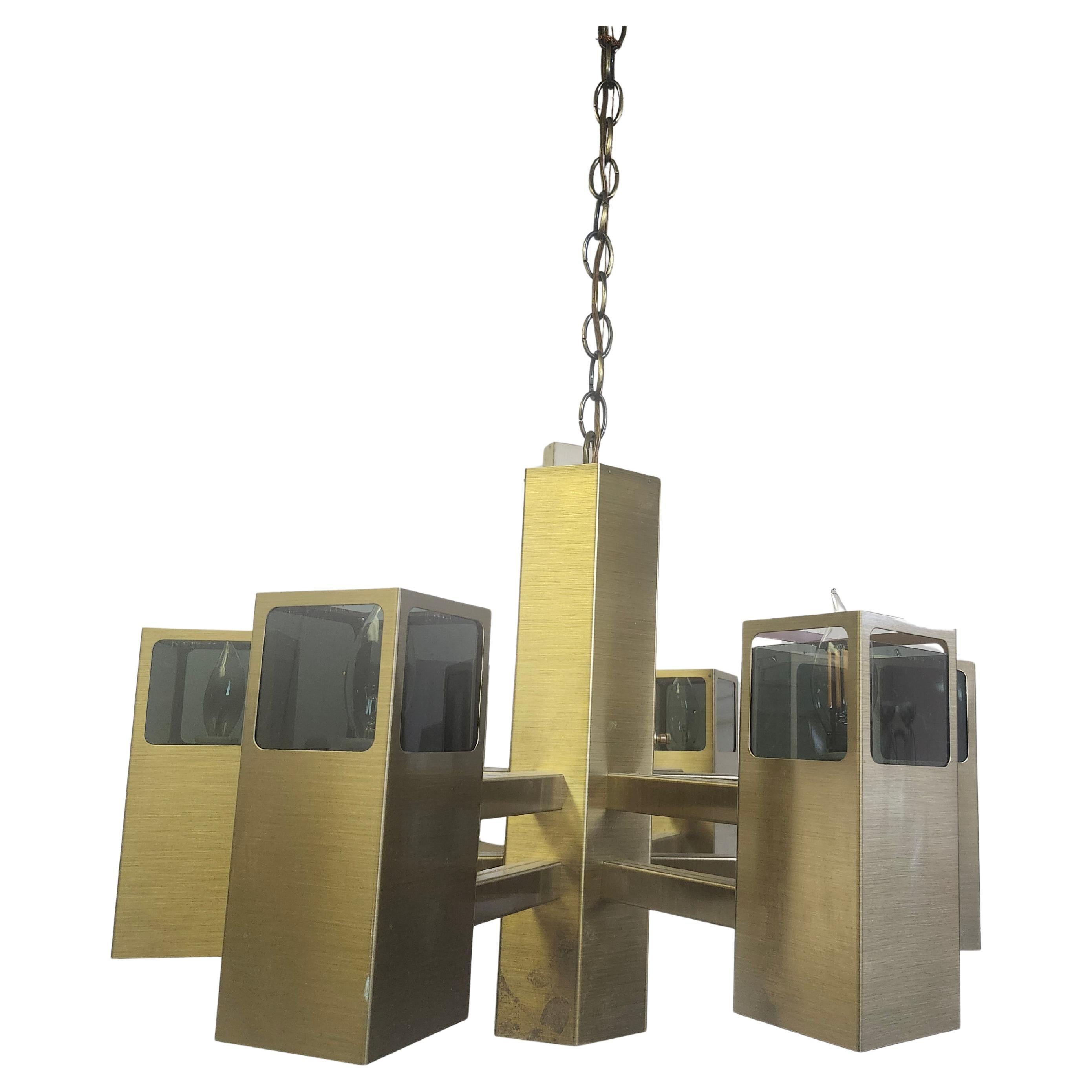 Fantastic chandelier by Frederick Raymond. Six Brass & Glass cannisters with an upper light which illuminates the glass portion and a light in the six bottom sections of brass which can be used separately or in conjunction with the top lights. Also