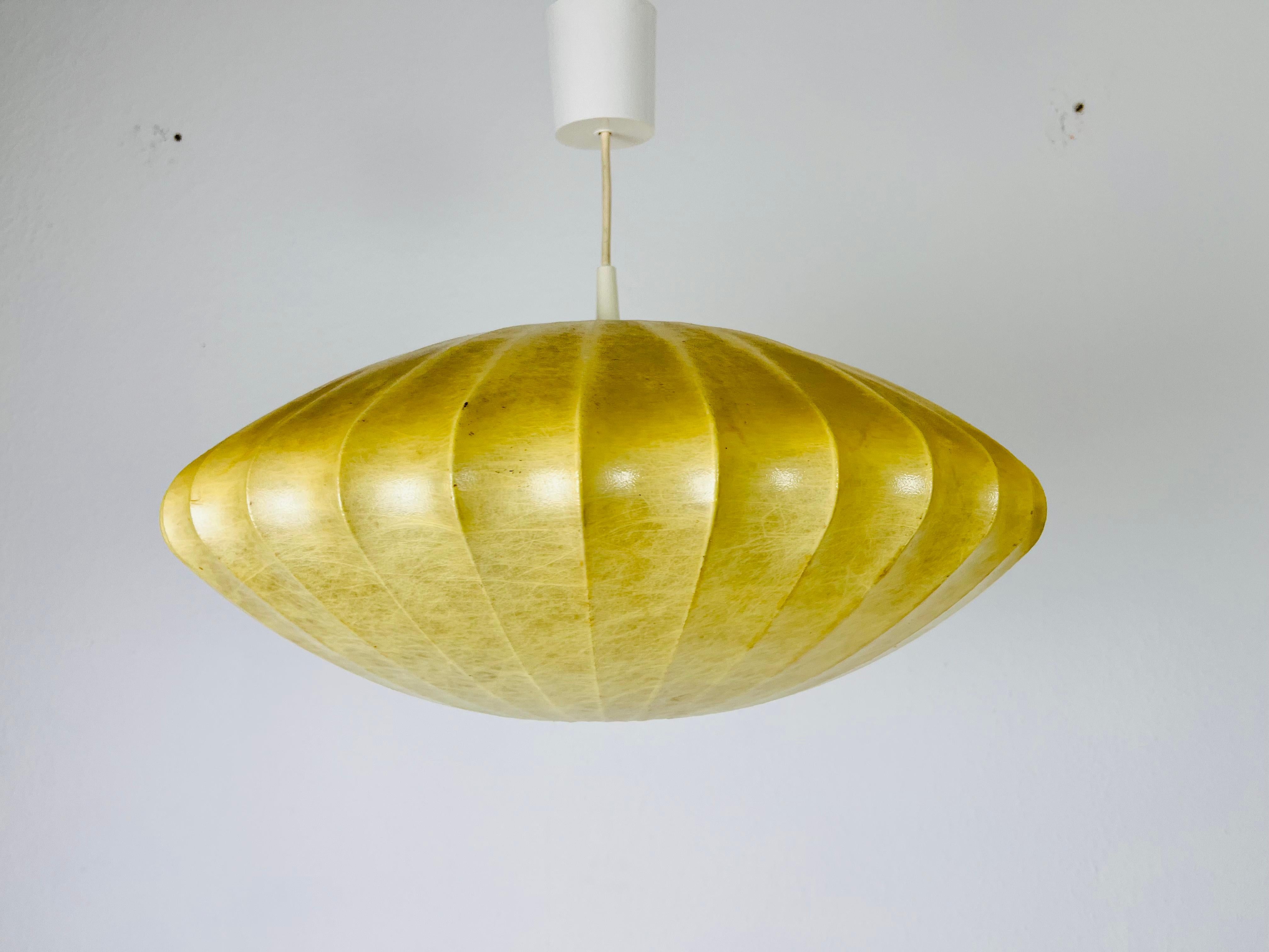 Una lampada a sospensione a bozzolo realizzata negli anni '60. Il materiale della lampada è la resina.

Dimensioni::
altezza: 22 cm - 40 cm

La lampada richiede una lampadina E27. Funziona sia a 120 che a 220 V. Buone condizioni