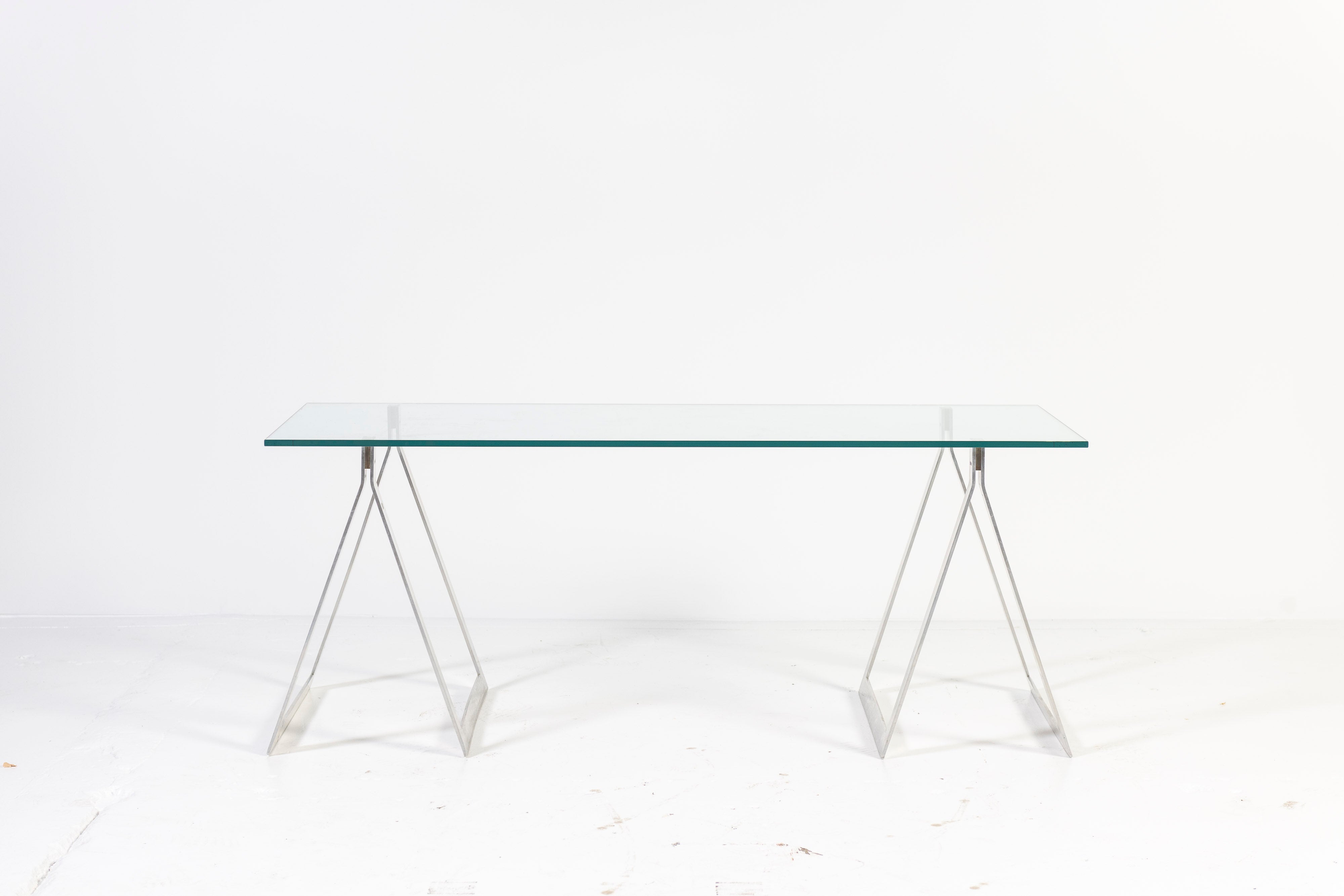 This iconic desk, designed in steel and glass, grounds a room without taking up visual space, thus a great option for both large and small spaces. The solid ground glass top, 1/2