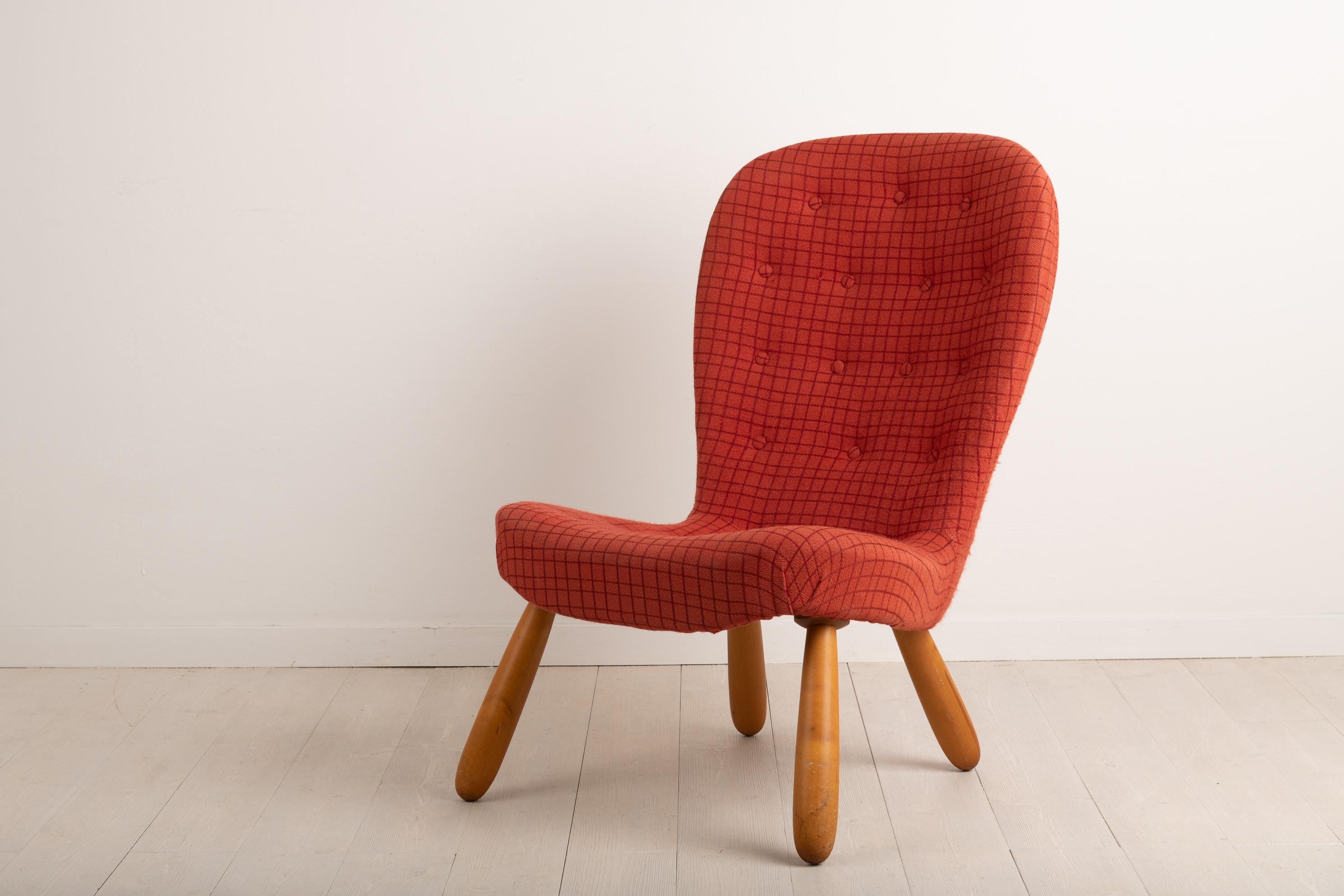 Clam chair or Muslinge armchair attributed to Philip Arctander. Designed and manufactured the mid-20th century the chair has a genuine retro feel. The bright coloured fabric and recognisable design ensures it's noticed in almost any room. Padded