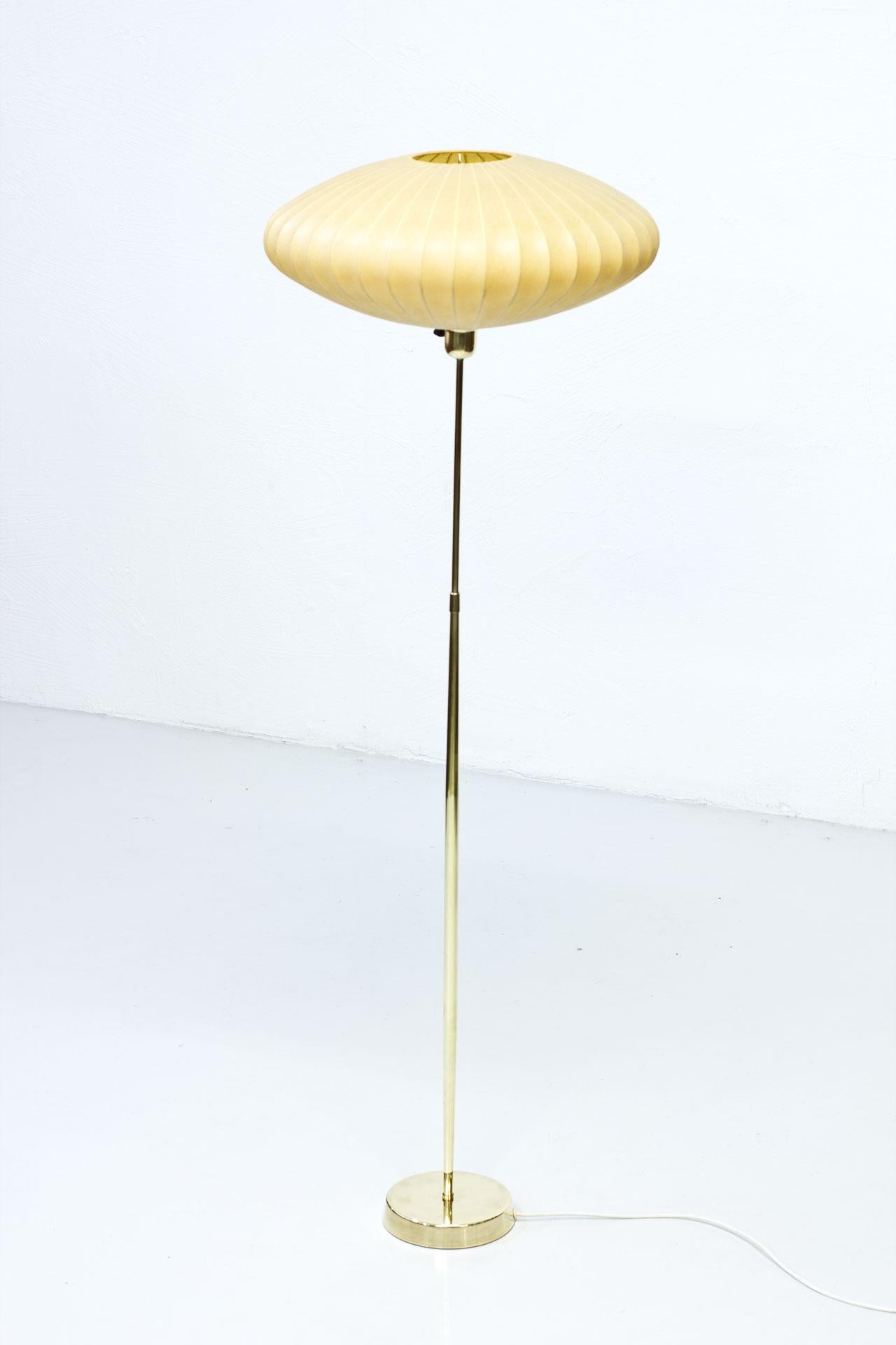 Floor lamp produced by ASEA belysning in Sweden during the 1950s. Polished brass stem. Cocoon sprayed plastic shade. Rewired. Light switch on the brass fitting.