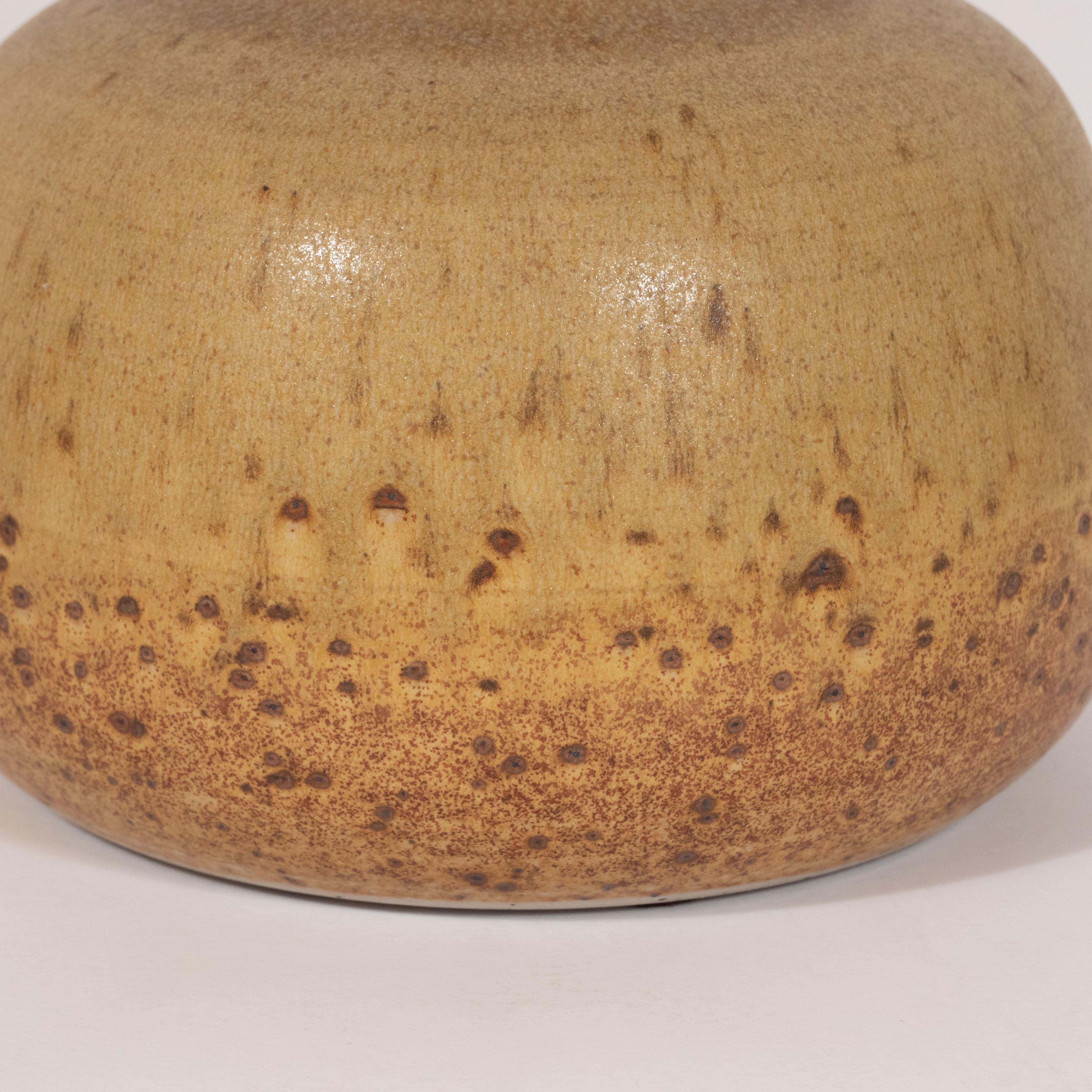 This elegant Mid-Century Modern decorative vase was realized in Denmark by the esteemed ceramic atelier of the period Per Linneman Schmidt for Palschus, circa 1960. It features a rounded body with a tapered neck and a circular mouth in a deep