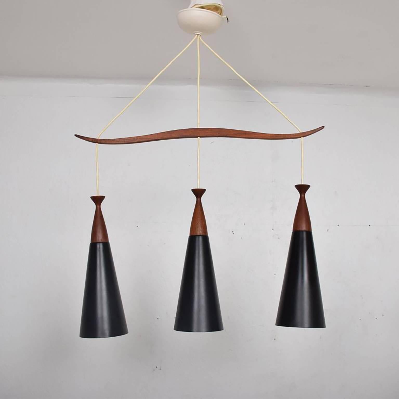 For your consideration, a vintage teak pendant lighting with three shades of aluminum painted in black with teak canopies. 
Beautiful sculptural shape.
Dimensions: 32