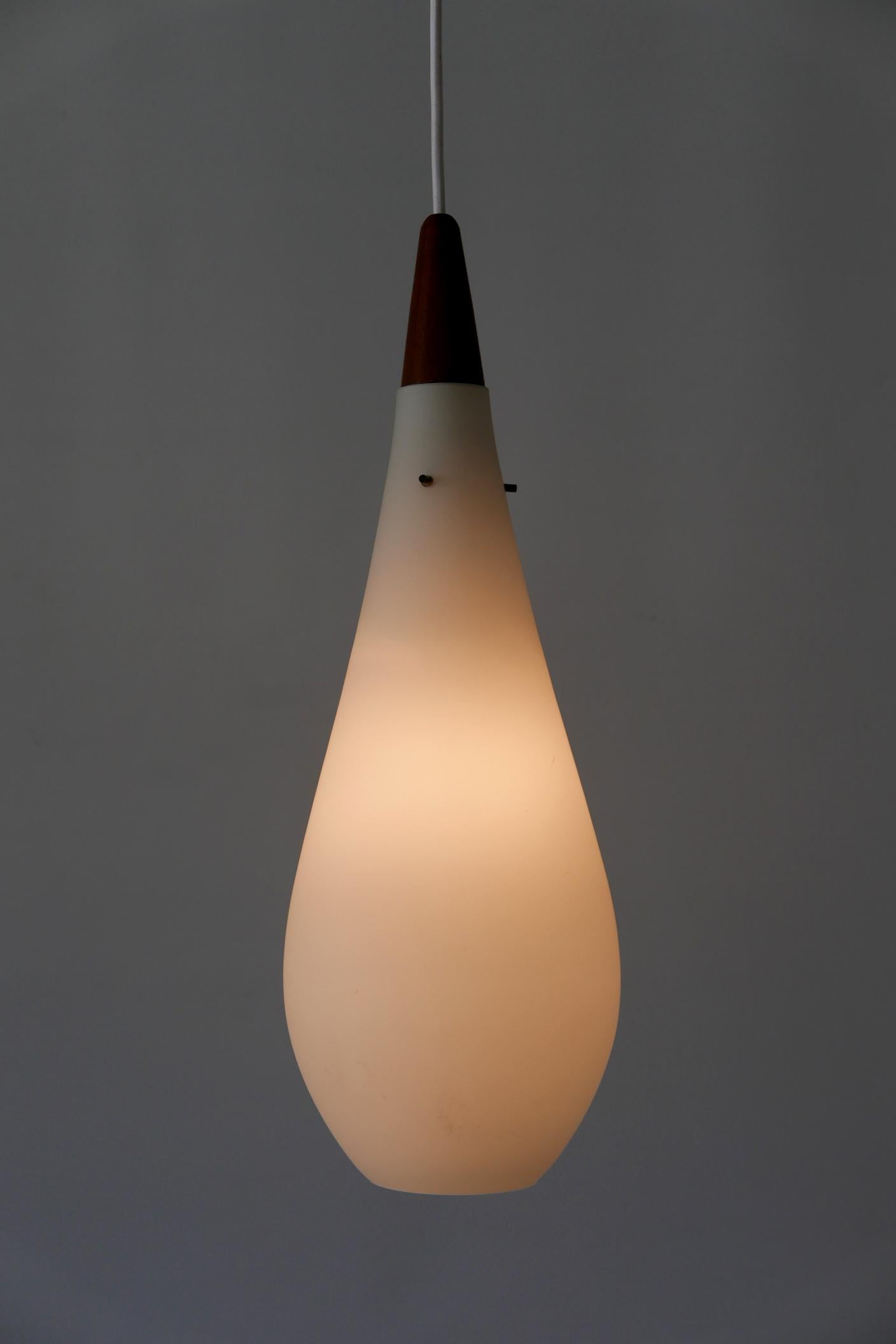 Lovely Mid-Century Modern Opaline glass and teak pendant lamp or hanging light. Designed and manufactured probably in Denmark in 1960s.

Executed in Opaline glass and teak wood, the lamp comes with 1 x E14 / E12 Edison screw fit bulb holder, is