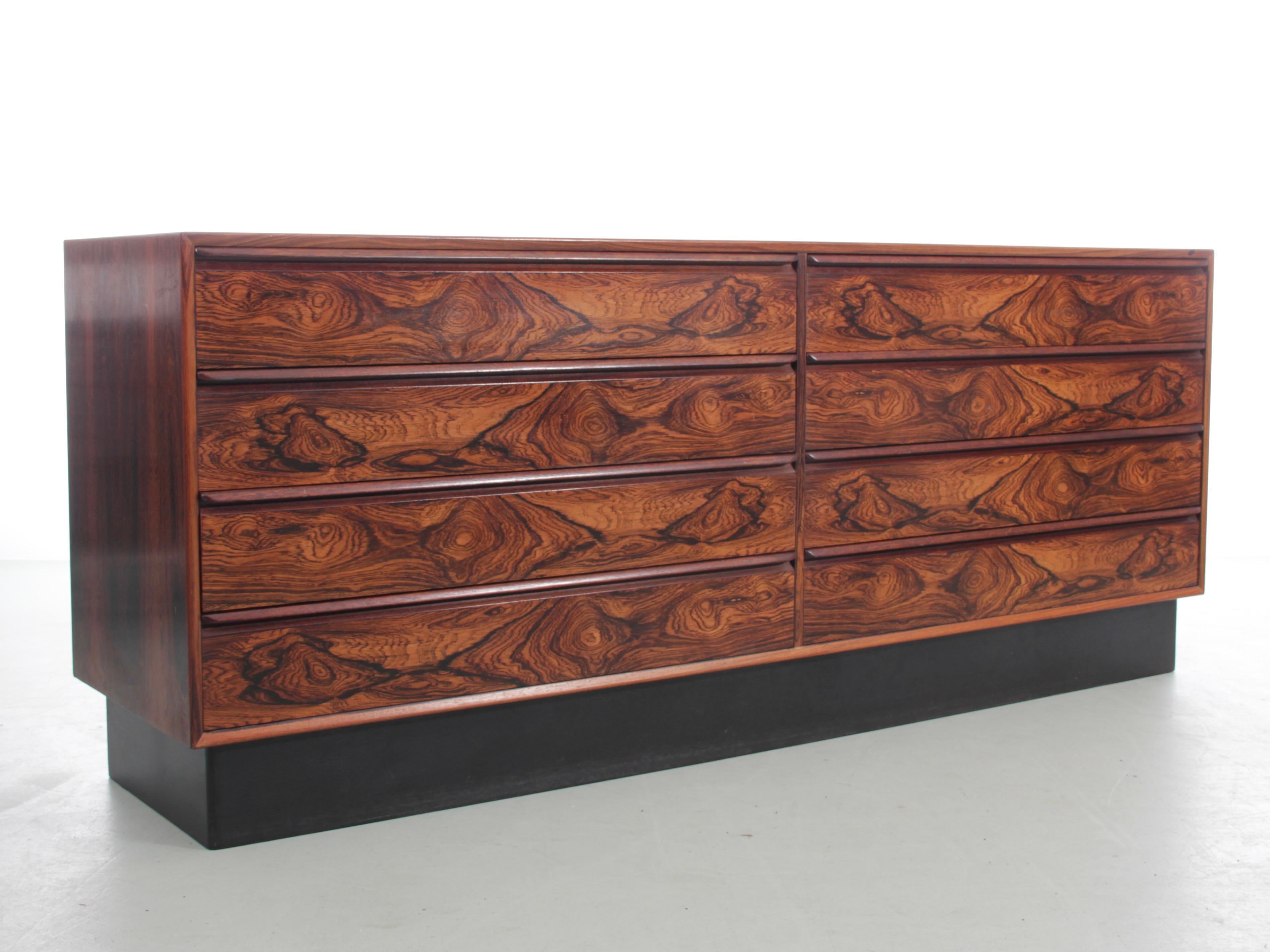 Cassettiera scandinava in palissandro con 8 cassetti. Posizionato su un basamento laccato nero. Eccellente artigianato. Interni dei cassetti in mogano. 

Ottime condizioni. Alcuni graffi sui cassetti e sul ripiano a destra. Leggero scolorimento