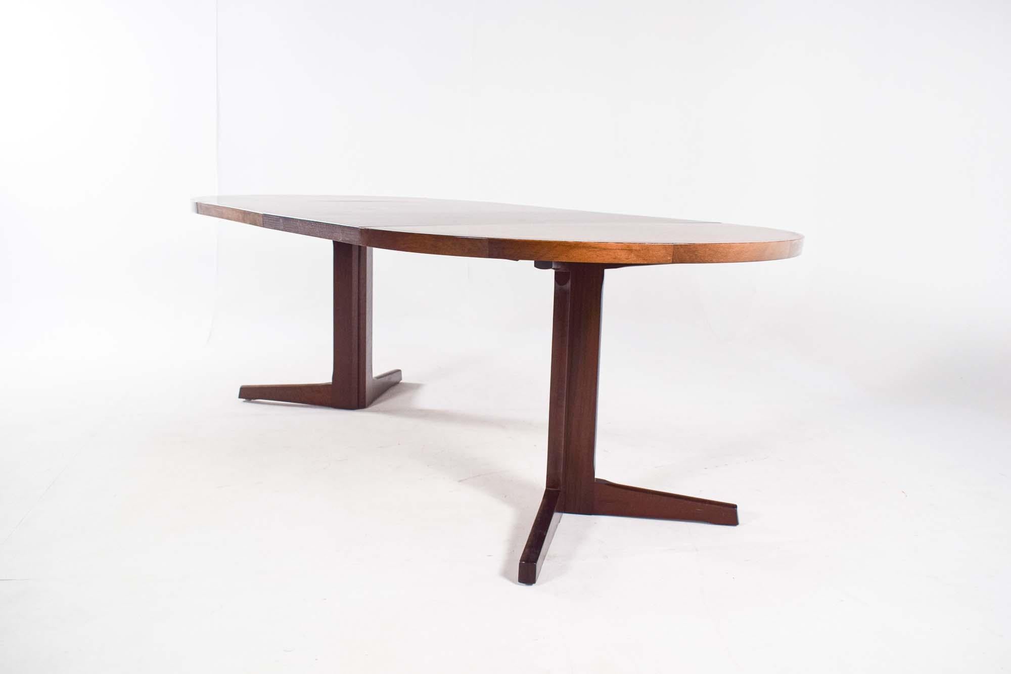 A beautiful ‘pedestal’ dining table with two leaves of 55 cm each. classic extendable dining table from the 1960s. Solid rosewood frame and table top in rosewood veneer. The table is supported by a cruciform pedestal base that comes apart whem table