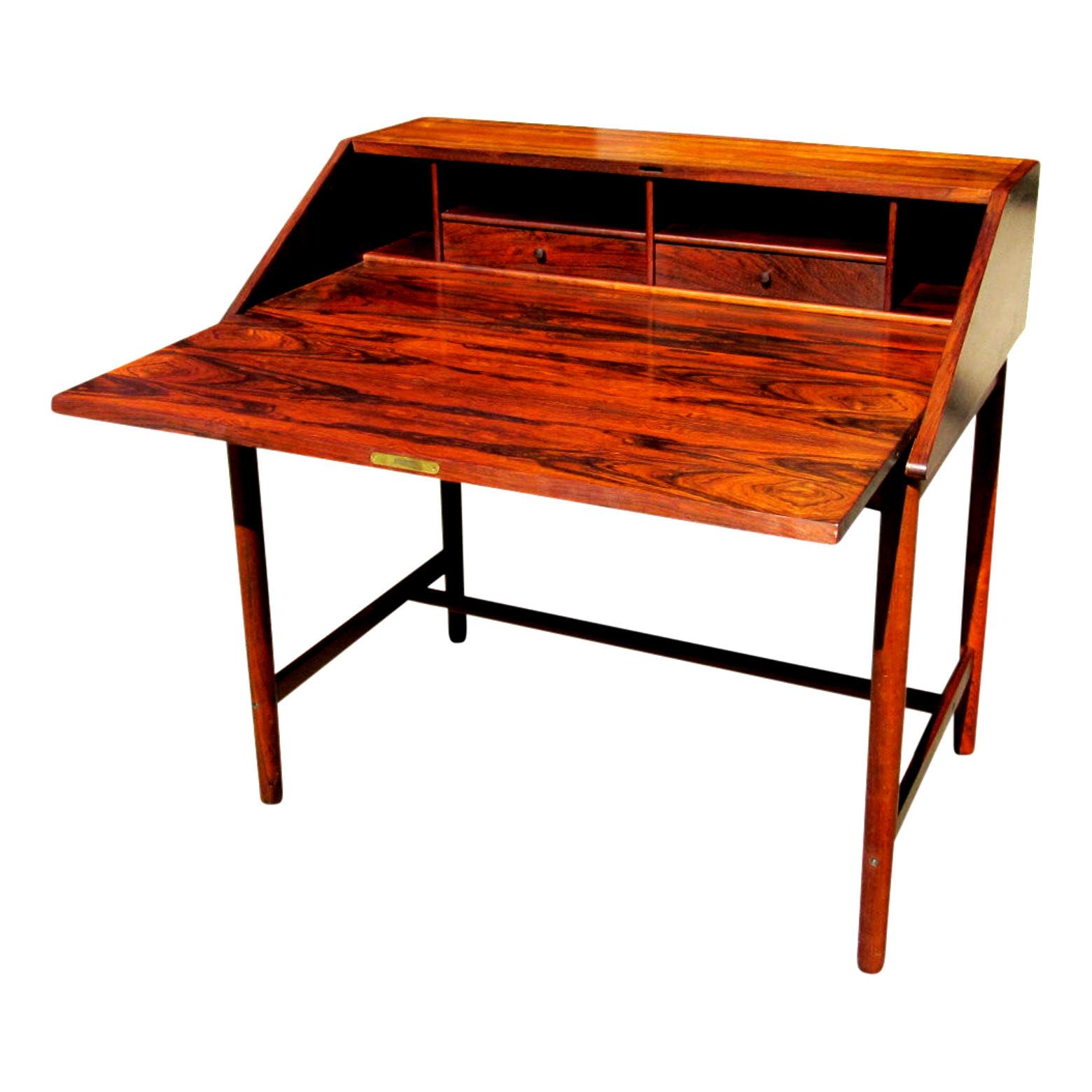 Mid-Century Modern Scandinavian writing desk in gorgeous Rio Rosewood, 1960s.  Often attributed to Drylund Denmark but Unmarked. Fold down top opens to reveal two drawers and four open storage areas.  Exceptional original condition. 