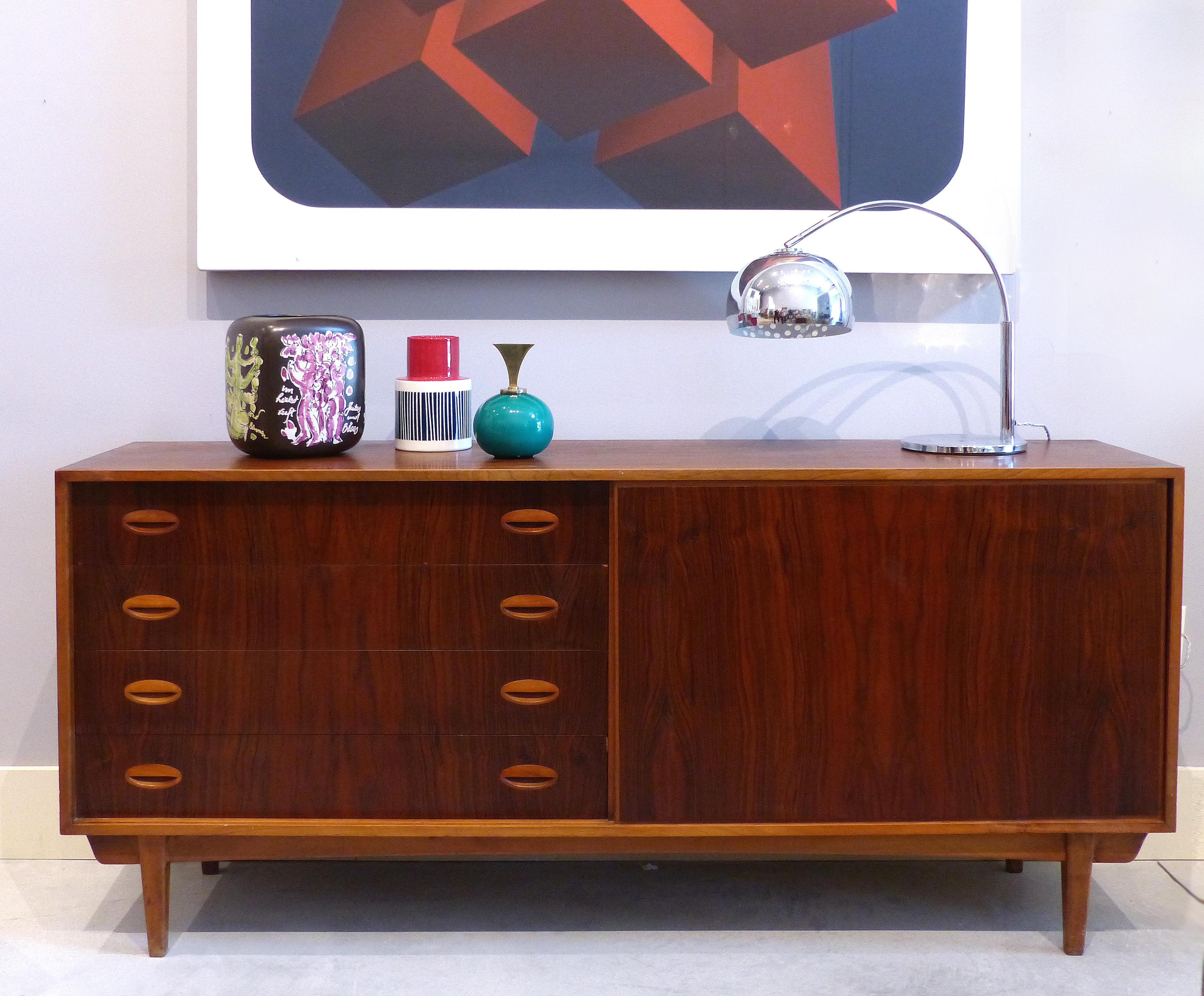 Mid-Century Modern Scandinavian Teak and Rosewood Credenza

Offered for sale is a Mid-Century Modern Scandinavian teak and rosewood credenza. The vertical rosewood grained door slides from side to side allowing for access to either the drawers to