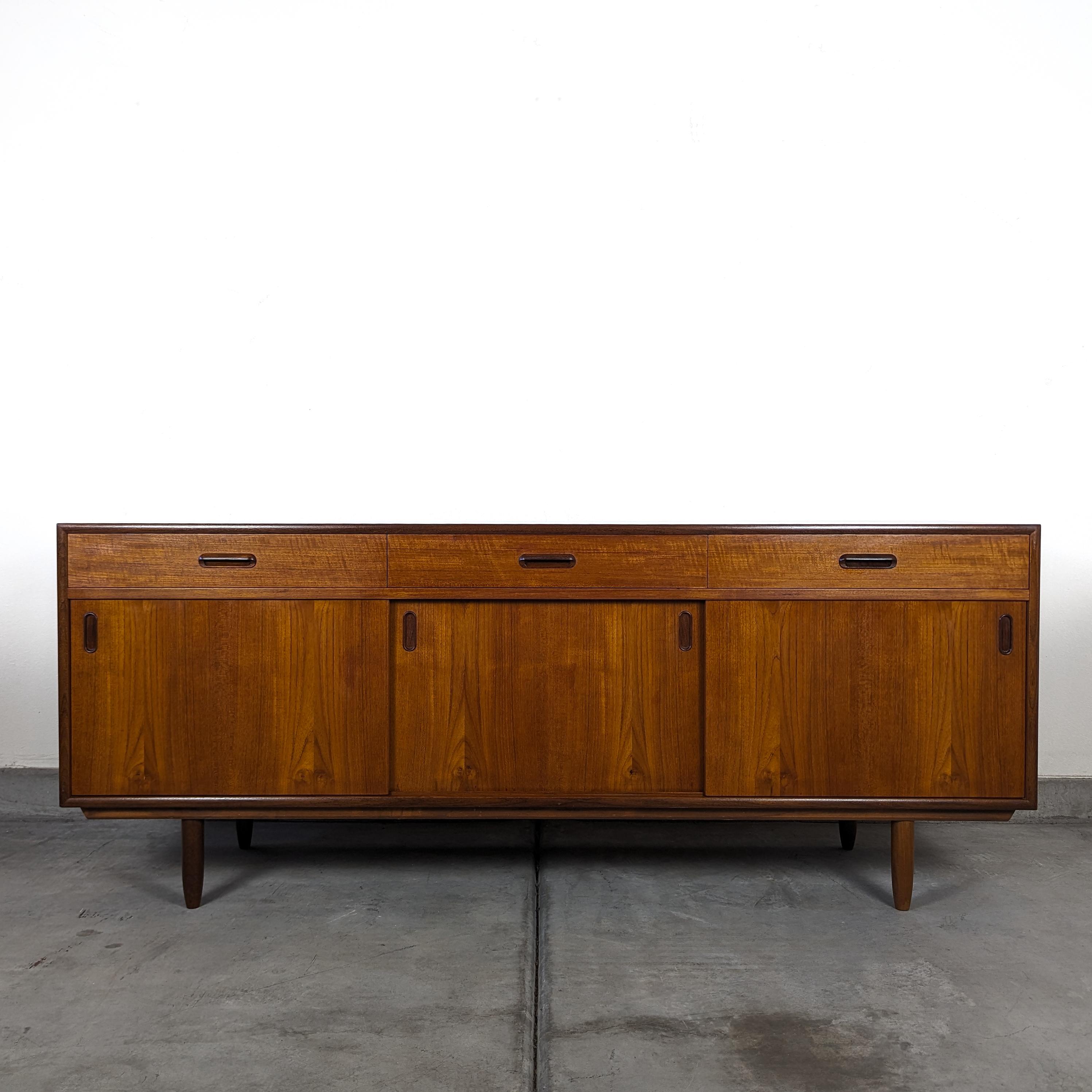 Experience the allure of Scandinavian design history with this mid century modern teak credenza/buffet. Originating from the heart of Scandinavia, where some of the most iconic and enduring furniture designs were born, this piece is a true testament