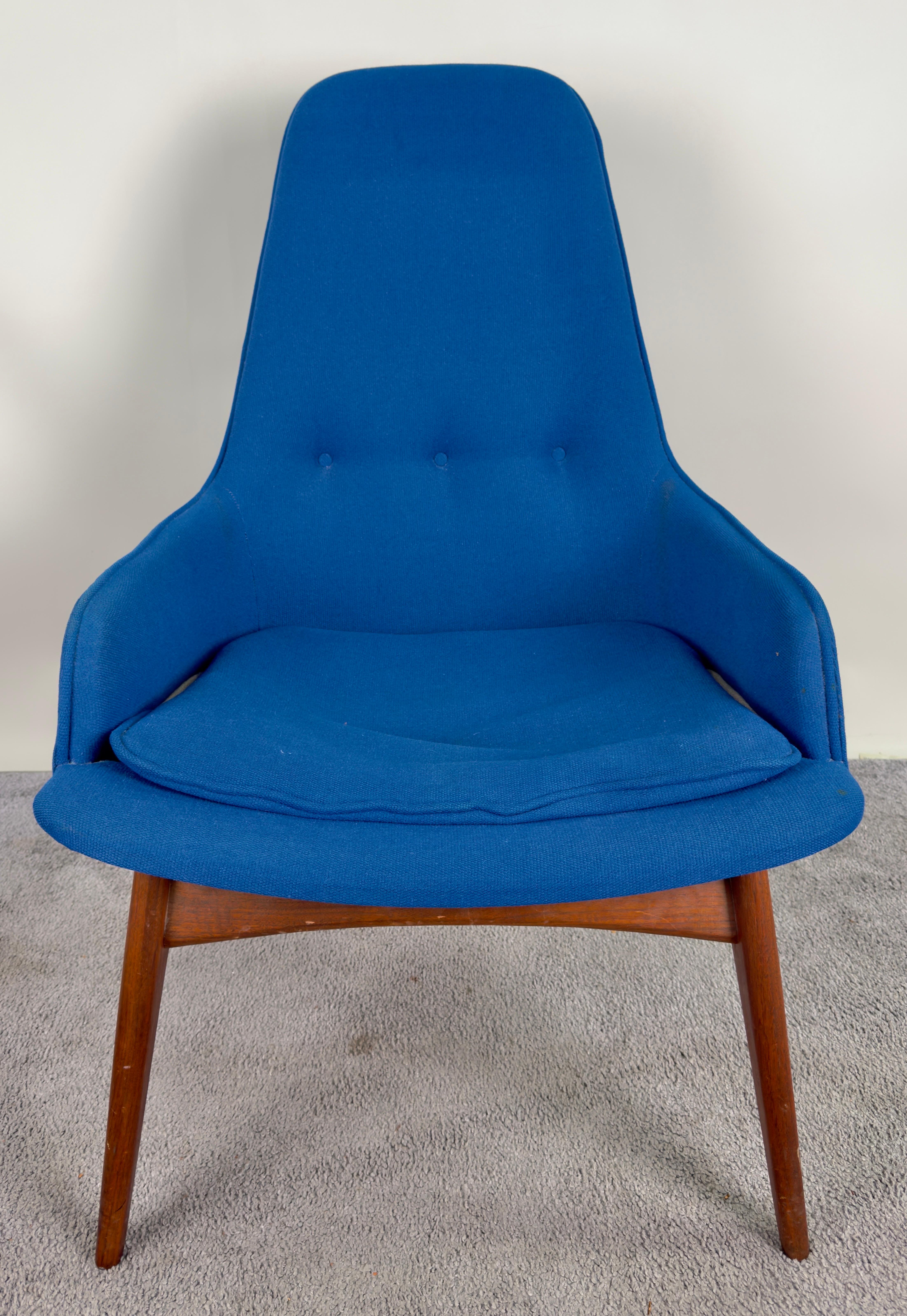 A Mid Century Modern Scandinavian barrel armchair. Crafted with meticulous attention to detail, this chair boasts a frame fashioned from the finest walnut, ensuring both durability and timeless elegance. Its upholstery, resplendent in cobalt blue is