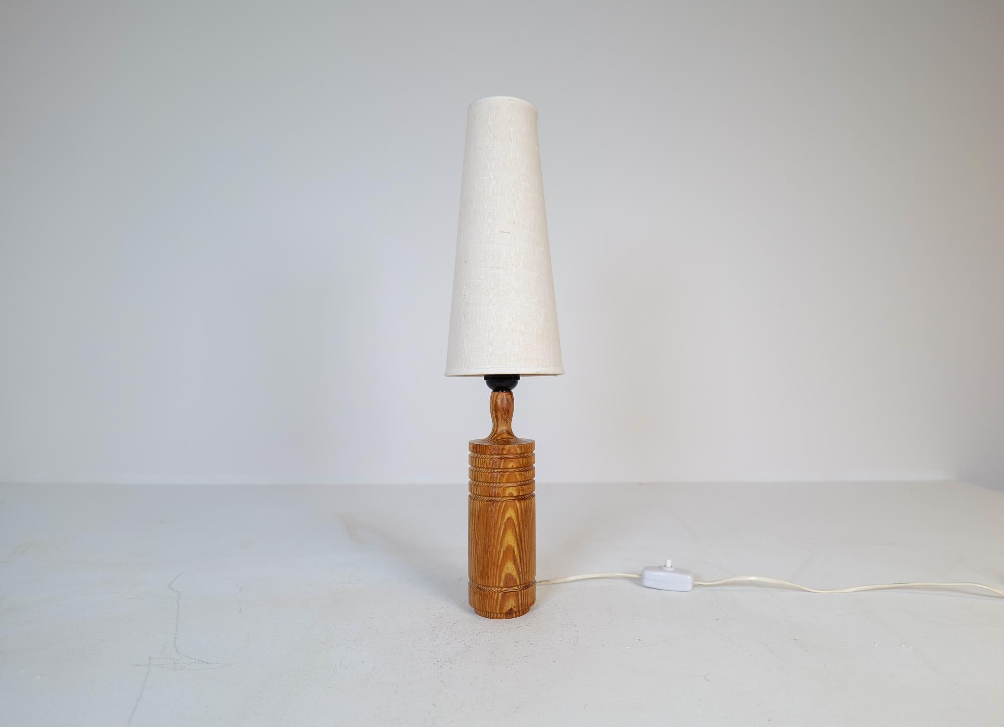 Table lamp produced in pine, designed by Lars Toller Timmersdala Sweden. Nice, sculptured table lamp with an original shade. 

Good working vintage condition, with wear consistent with age and use. 

Dimensions: Heigh with shade 53 cm base 10 cm