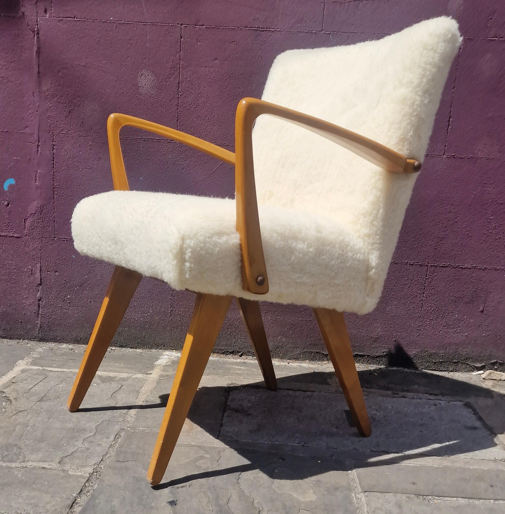 Superbly crafted scissor armchair from the 1950s
reupholstered in sheep skin
by lifting the armrest the crossed legs unfold to rise
chair to a new height