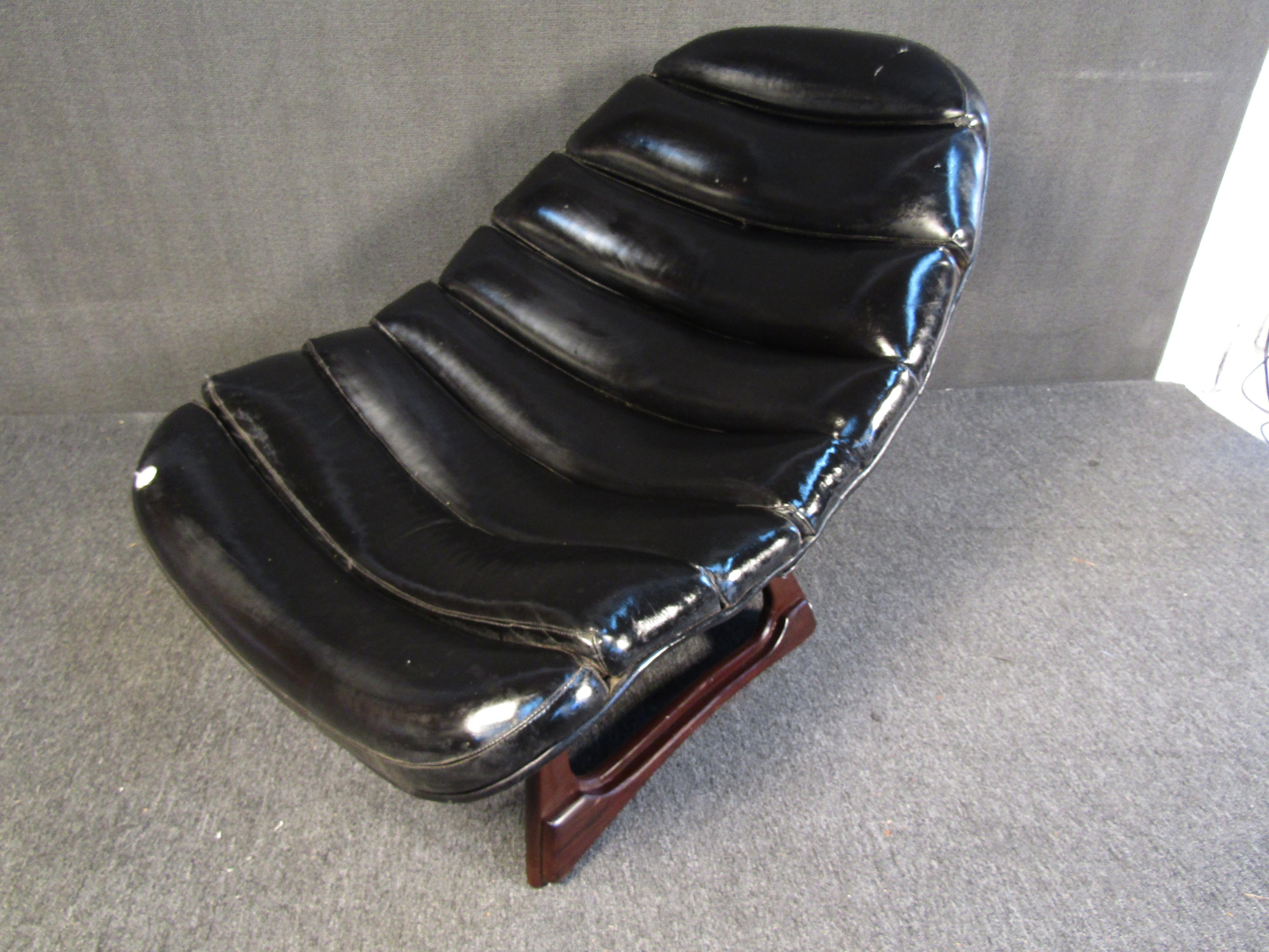 An iconic design by Adrian Pearsall, this Mid-Century Modern lounge chair features sleek black leather and rich walnut bases. This eye-catching chair is perfect for adding bold mid-century flair to any home. Please confirm item location with seller
