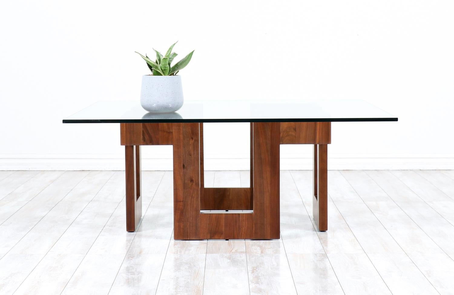 Table basse en noyer sculpté géométrique avec plateau en verre.

________________________________________

Transformer un meuble moderne du milieu du siècle, c'est comme redonner vie à l'histoire, et nous entreprenons ce voyage avec passion et