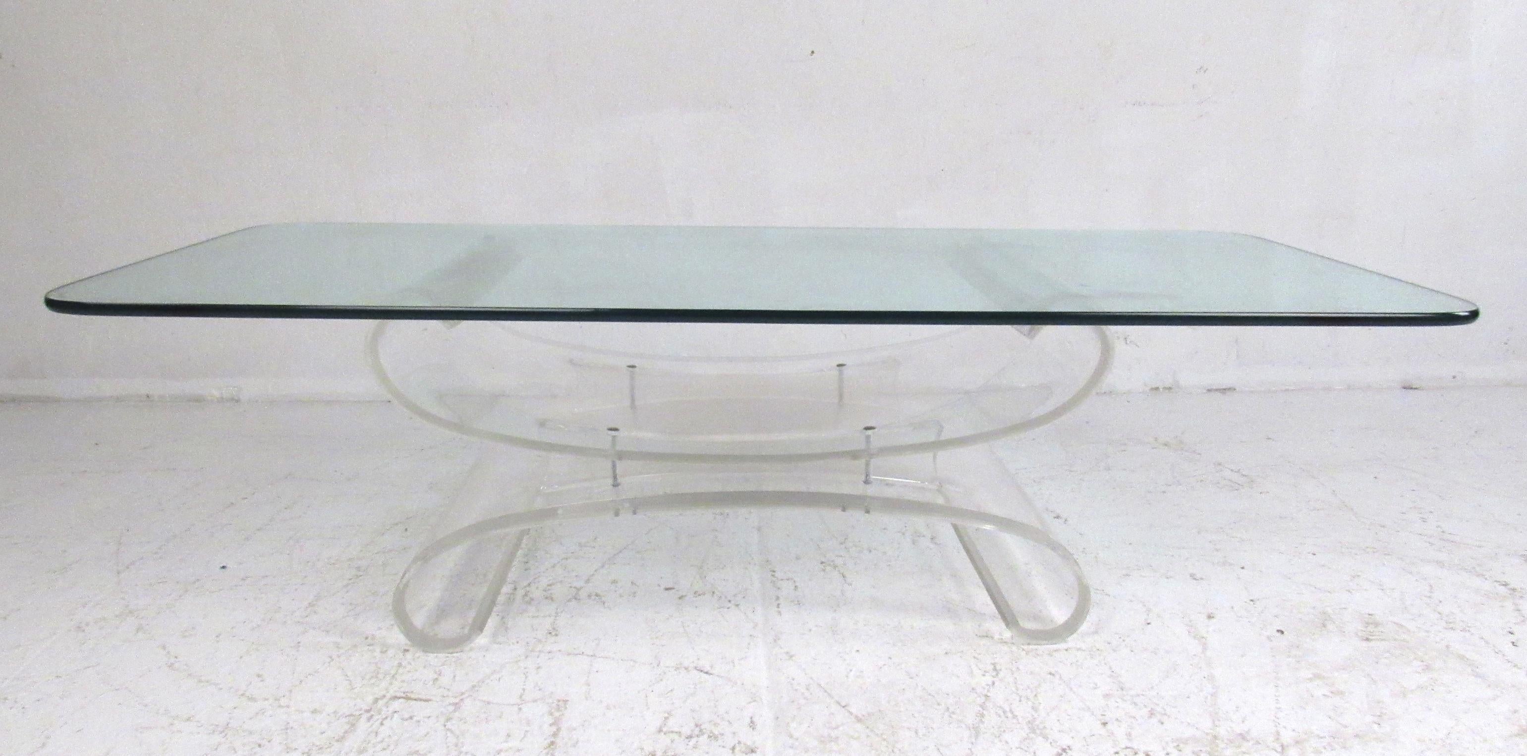 This beautiful vintage modern coffee table boasts an unusual sculpted Lucite base. A large rectangular piece of glass that is 3/4 inches thick sits comfortably on top. A butterfly shaped design with sides that curve inward show quality construction.
