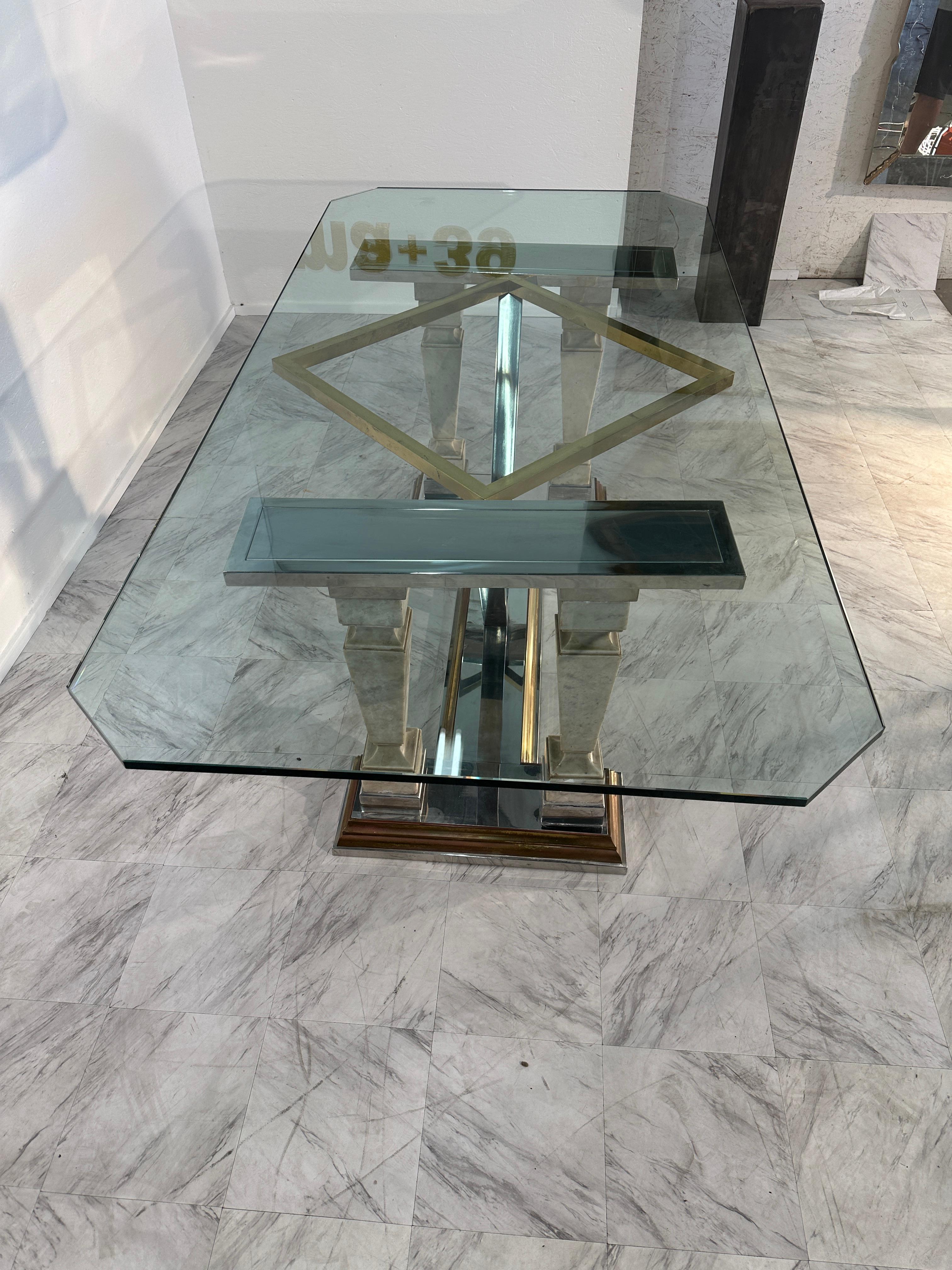 The Mid-Century Modern Sculpted Metal and Marble Dining Table from the 1970s is an elegant piece of furniture known for its sculptural metal base, marble accents, and a glass top. This design embodies the iconic mid-century modern style, combining