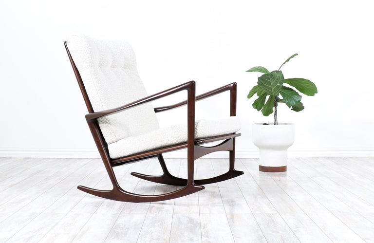 Rare modern rocking chair designed by Ib Kofod-Larsen for Selig in Denmark circa 1960s. This elegant rocking chair frame is crafted in walnut-stained beechwood with an open back and sculpted armrests creating a gorgeous modern profile. This iconic
