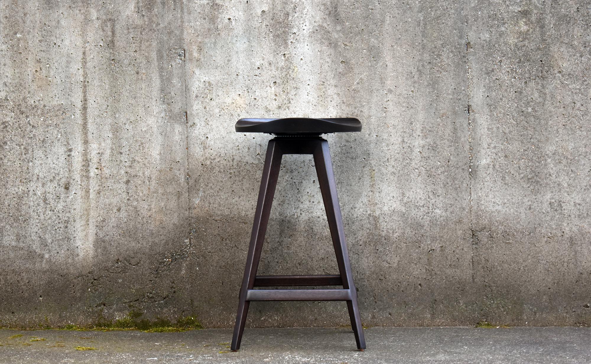 Mid-Century Modern swiveling stool with hand-sculpted low-profile backrest and tractor-style seat. 

The frame is built using mortise and tenon construction. The seat and backrest are formed by carefully selecting thick blocks of lumber which are
