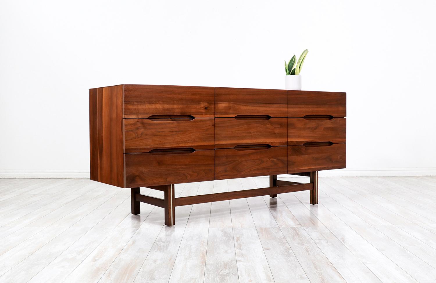 American Mid-Century Modern Sculpted Walnut 9-Drawer Dresser with Brass Accent  For Sale