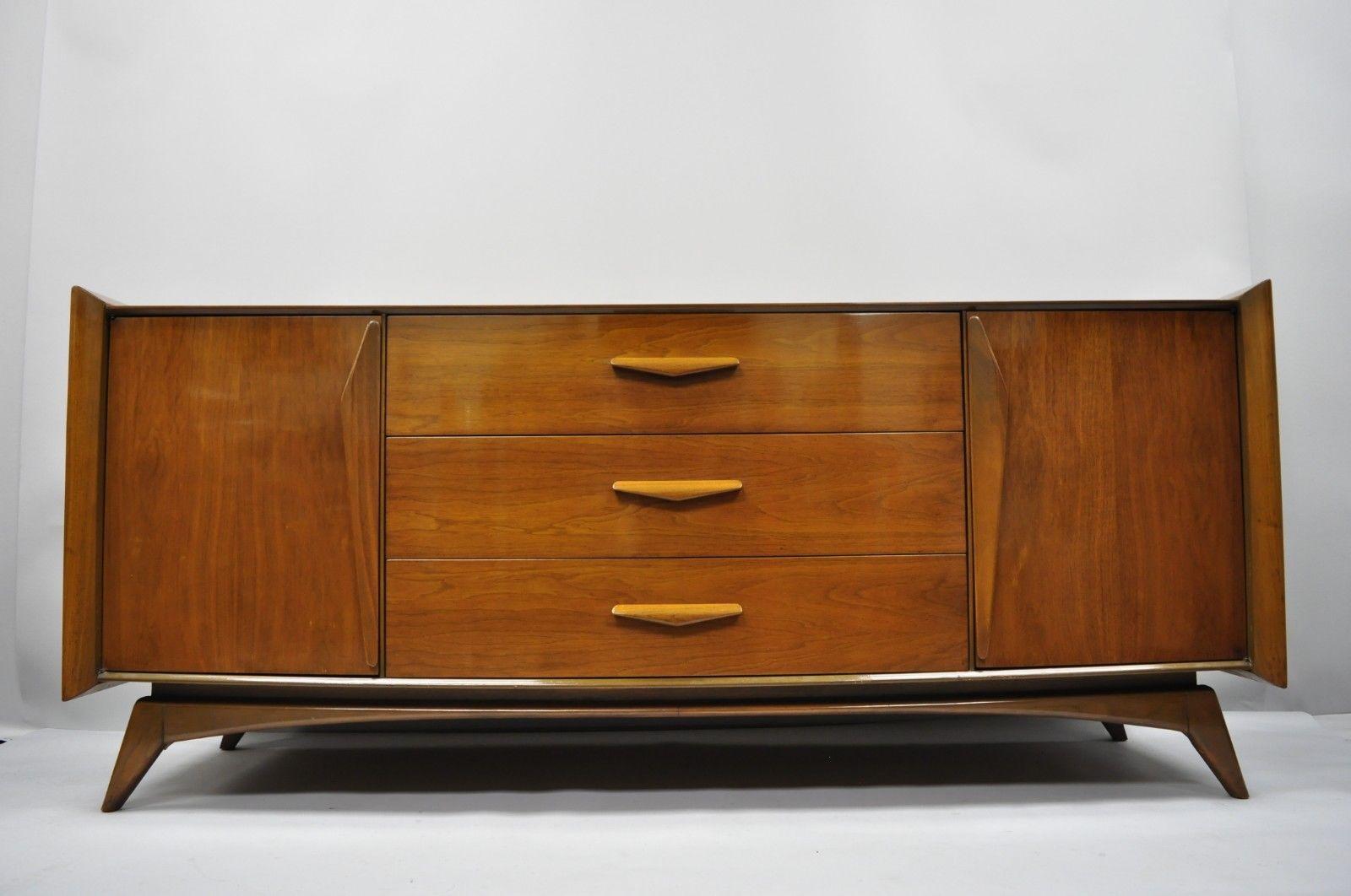 Mid-Century Modern sculpted walnut credenza long dresser. Item features raised panel sculpted wood sides, sculpted wood pulls, beautiful wood grain, 2 swing doors, 9 dovetailed drawers, tapered legs, sleek sculptural form, circa 1960. Measurements:
