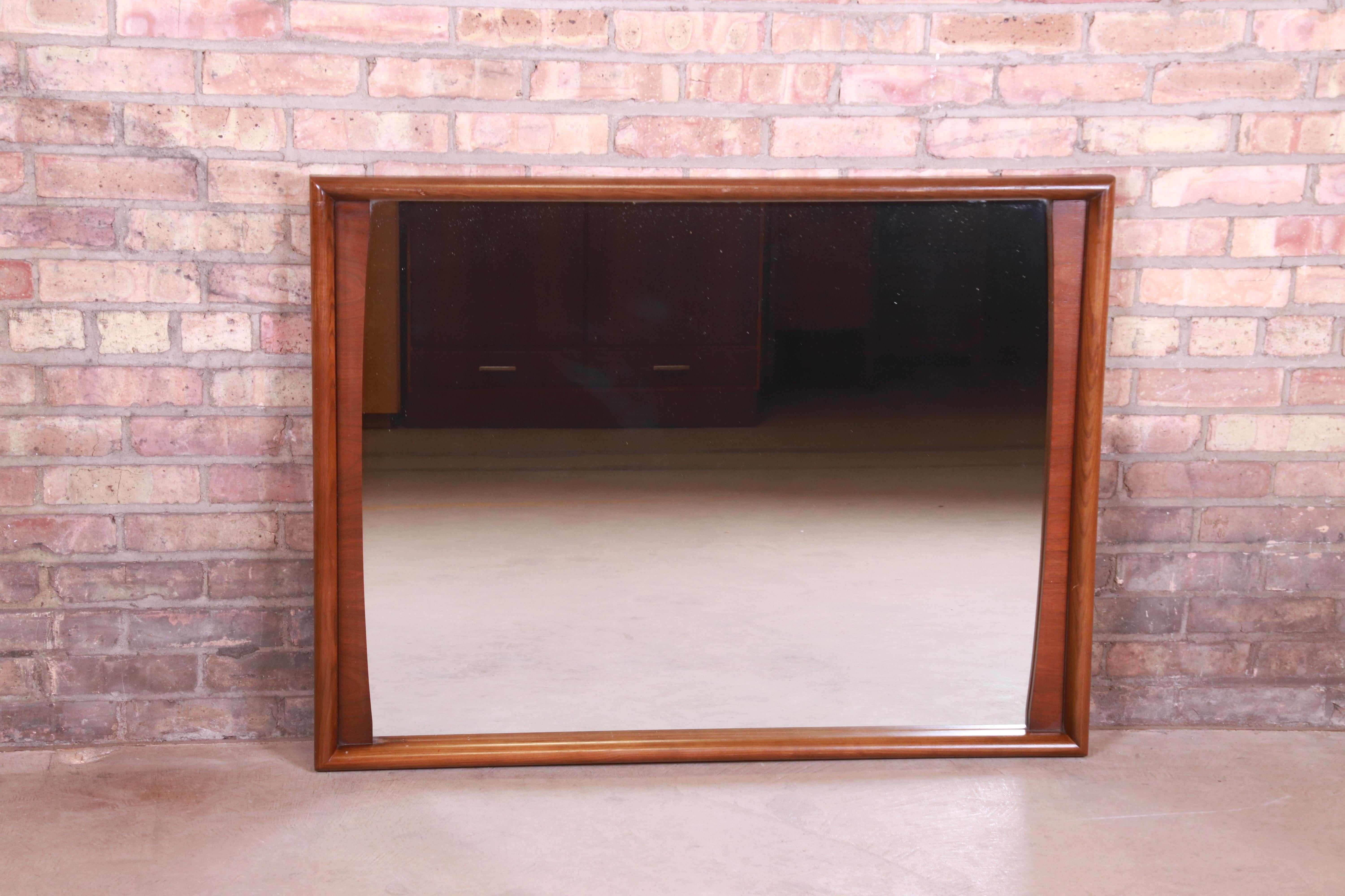 A stylish Mid-Century Modern sculpted walnut framed wall mirror

By United Furniture

USA, 1960s

Measures: 42.5
