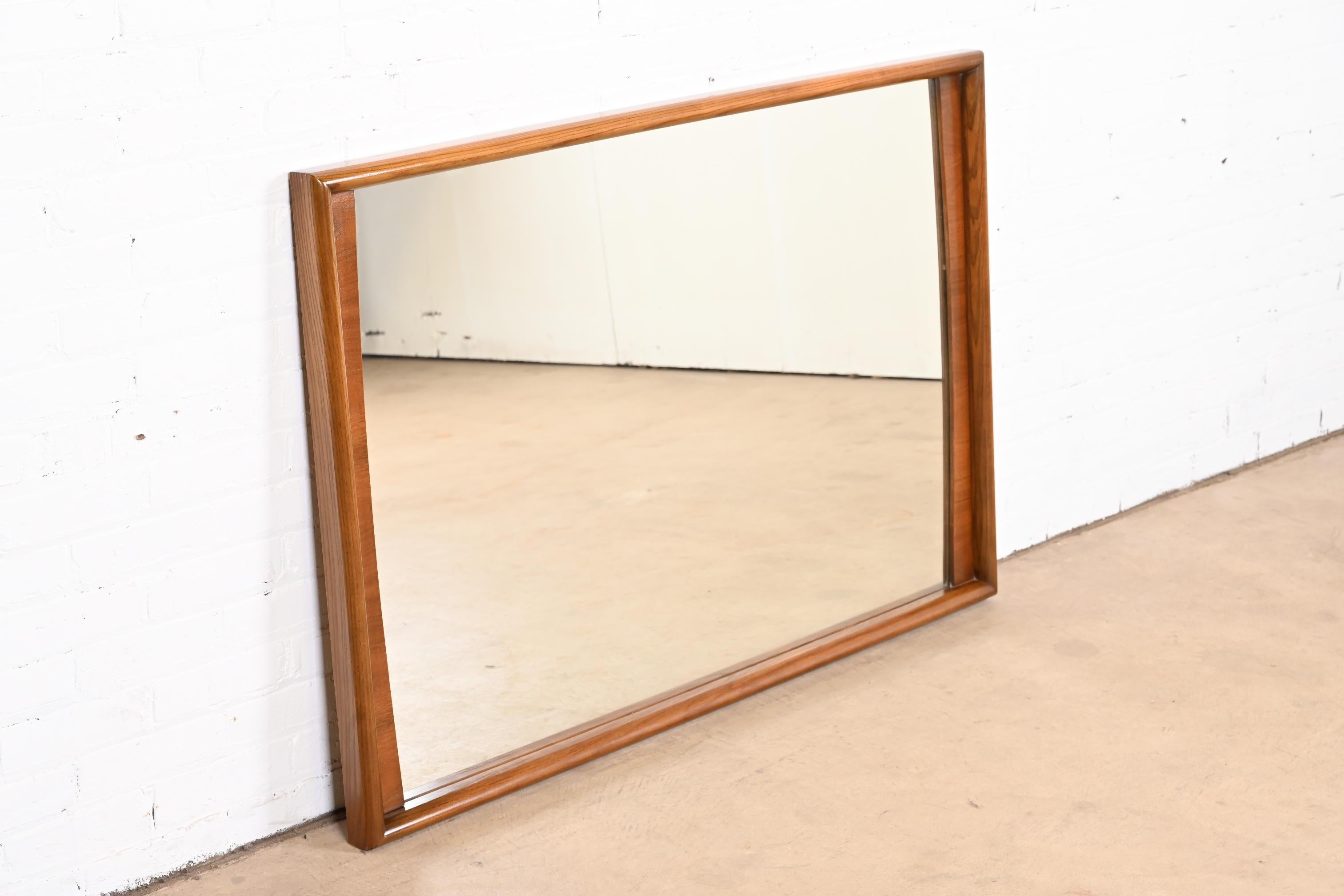 A stylish Mid-Century Modern sculpted walnut framed wall mirror

By United Furniture Co.

USA, 1960s

Measures: 50.63