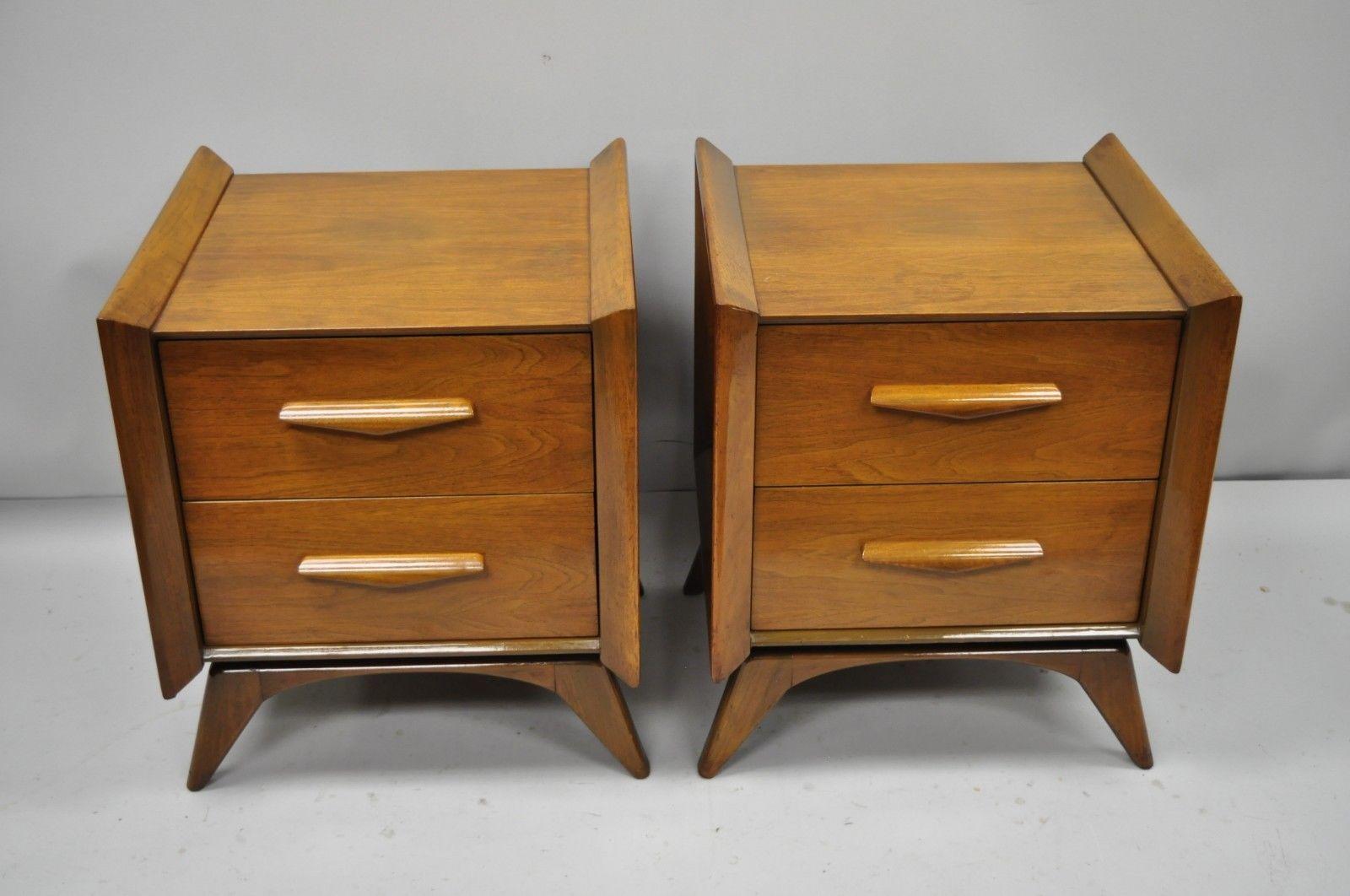 Mid-Century Modern sculpted walnut nightstands. Item features raised panel sculpted wood sides, sculpted wood pulls, beautiful wood grain, tapered legs, and great style and form, circa mid-20th century. Measurements: 25.5